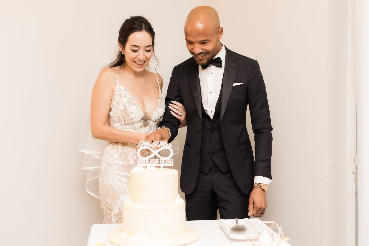 Couple shares an intimate moment while cutting their wedding cake together.