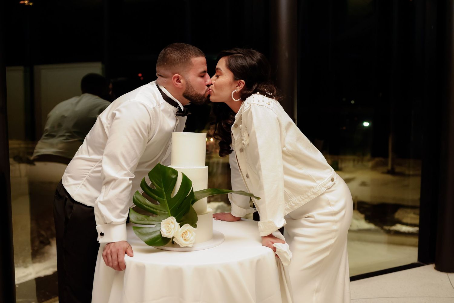 A couple shares a romantic moment over their wedding cake.