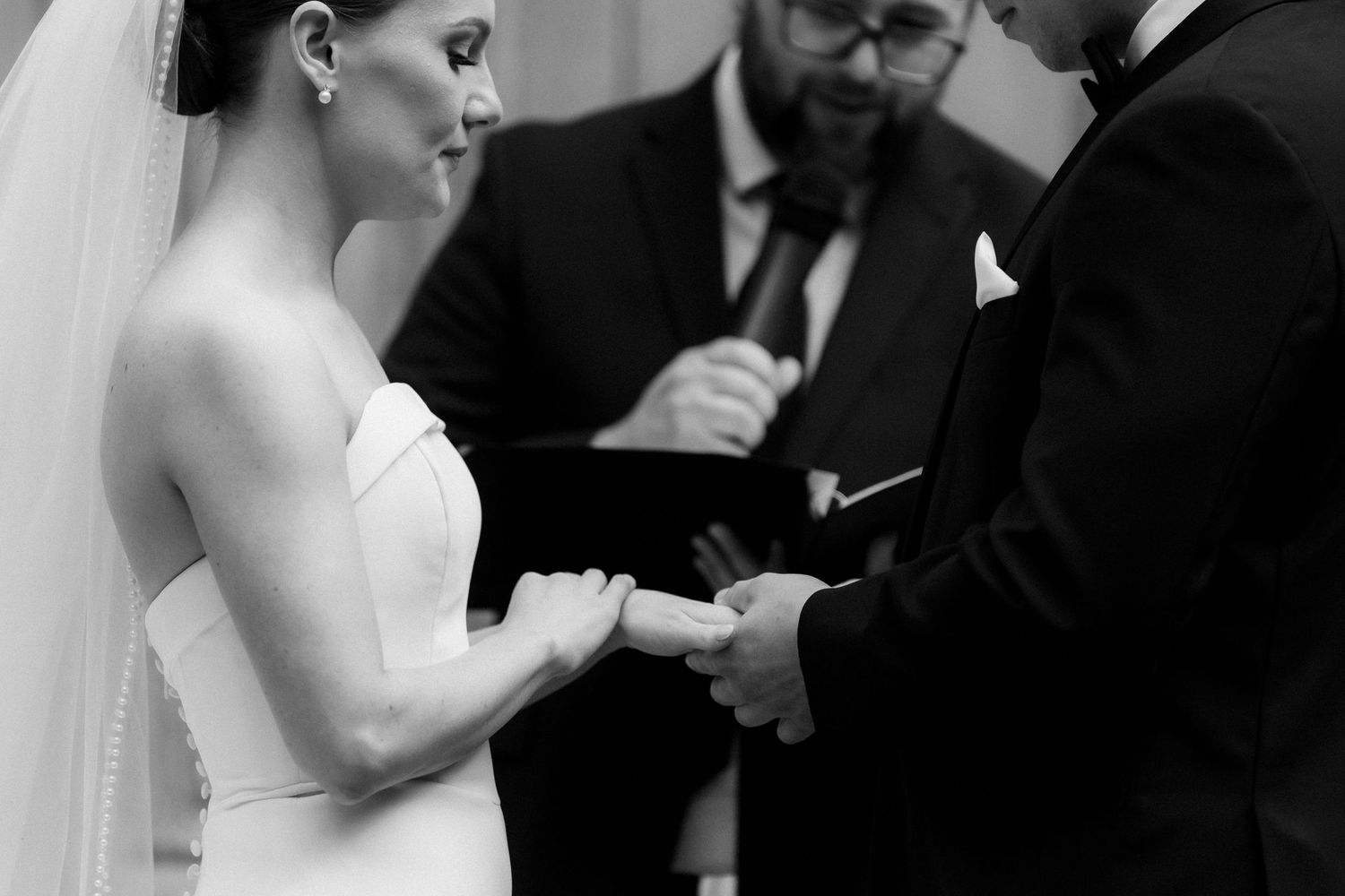 A couple participates in an emotional wedding ceremony as they exchange vows in front of an officiant.