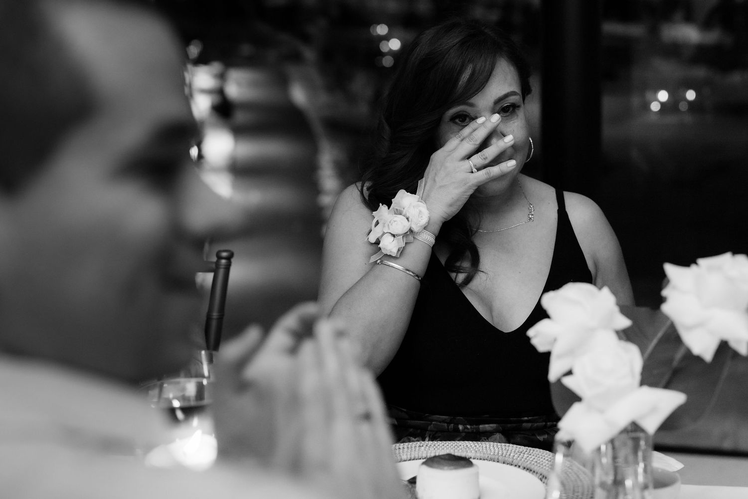 An emotional moment captured in black and white during a wedding reception.
