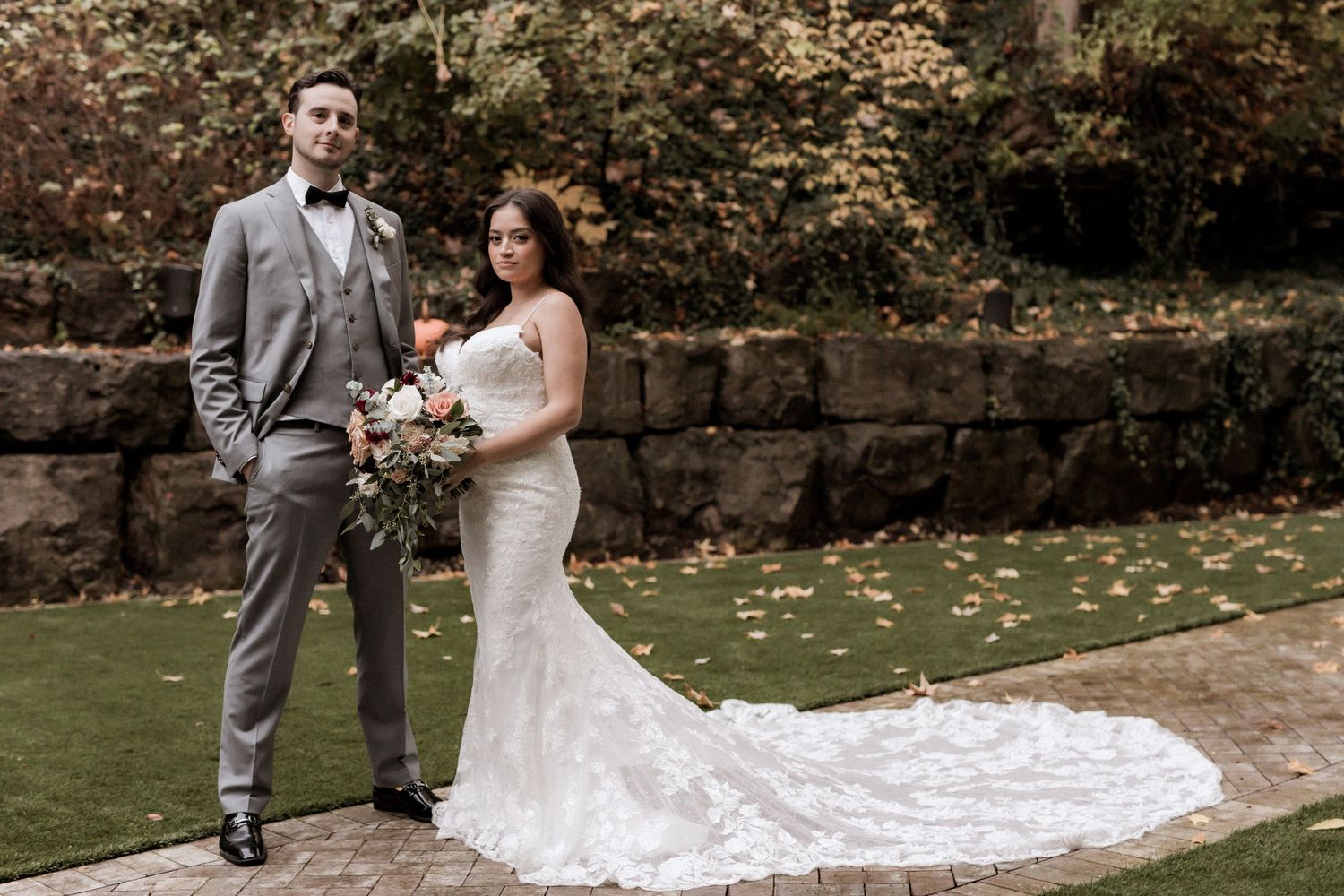 Elegant wedding portrait featuring mermaid lace gown with cathedral train against autumn backdrop.