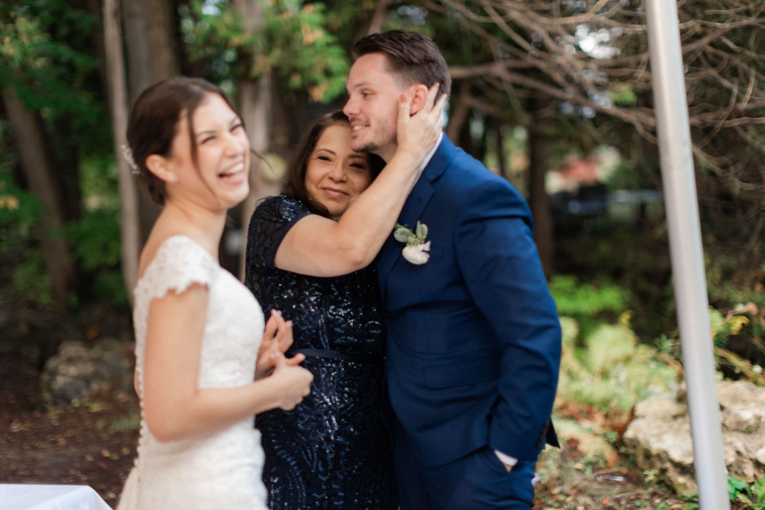 A joyful wedding moment captured with guests embracing during outdoor celebrations.