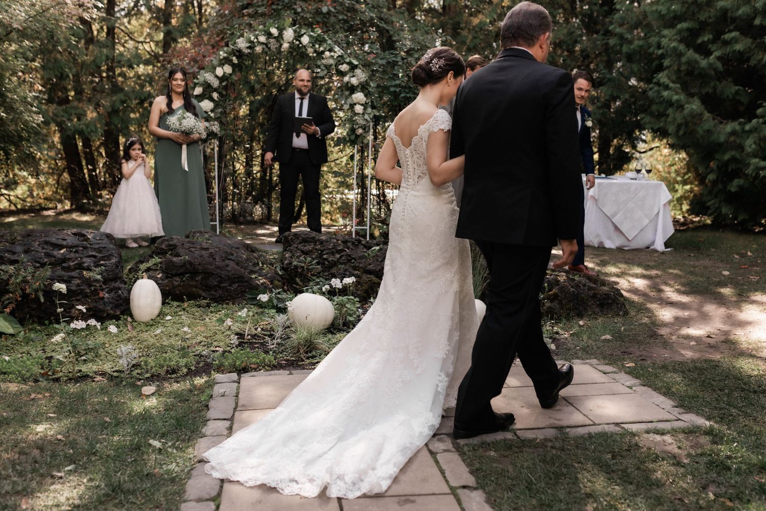 Romantic forest wedding portrait with couple surrounded by tall trees and natural lighting.