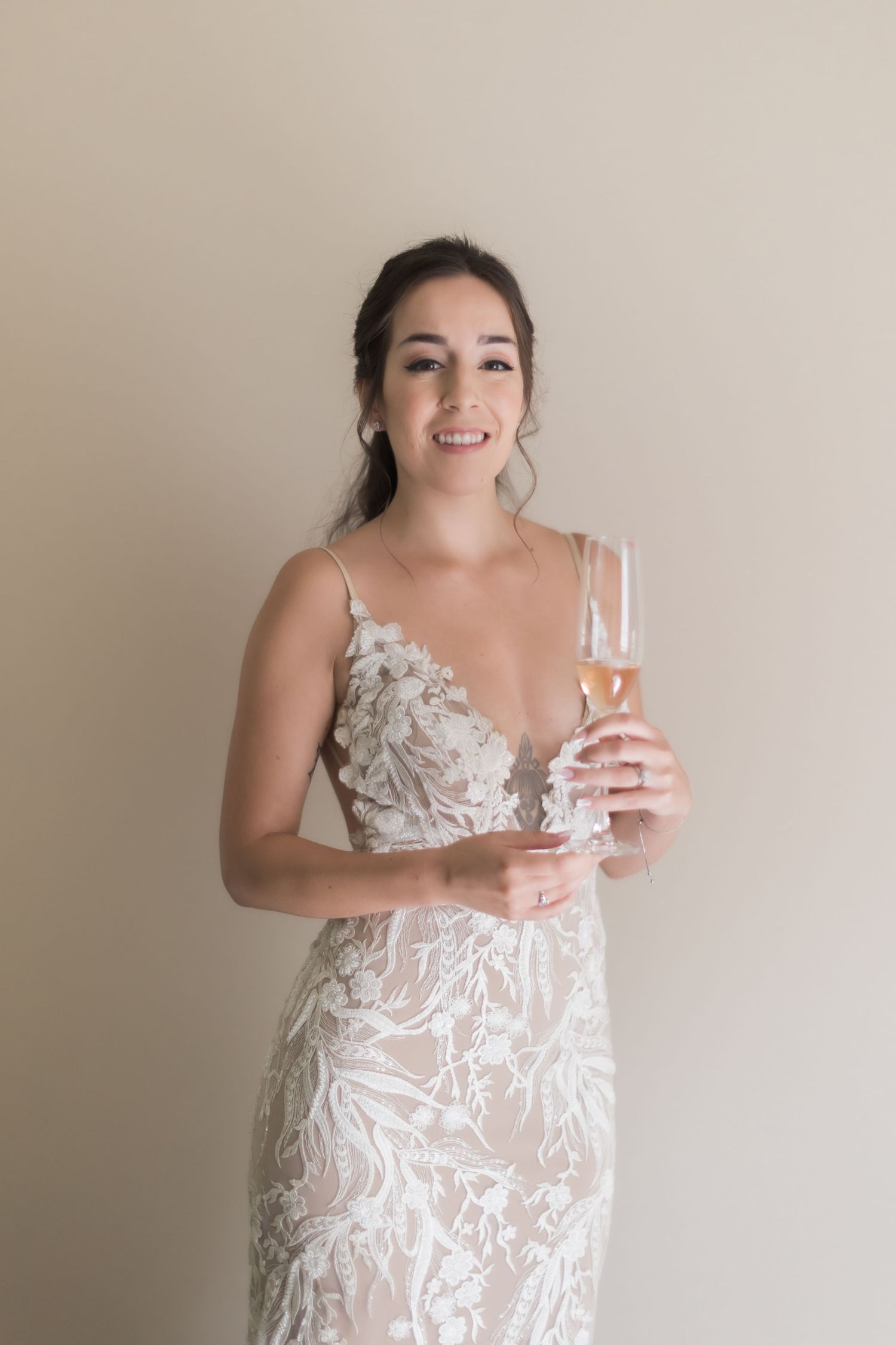 A joyful moment in a fitted white lace wedding gown with intricate floral details.