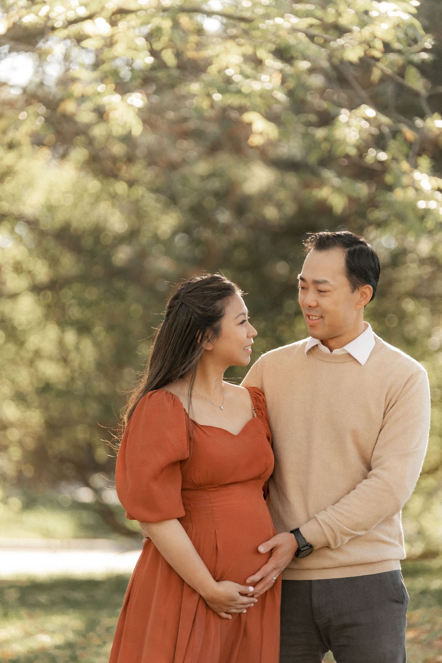 Romantic outdoor maternity photo of couple in coordinated autumn colors.