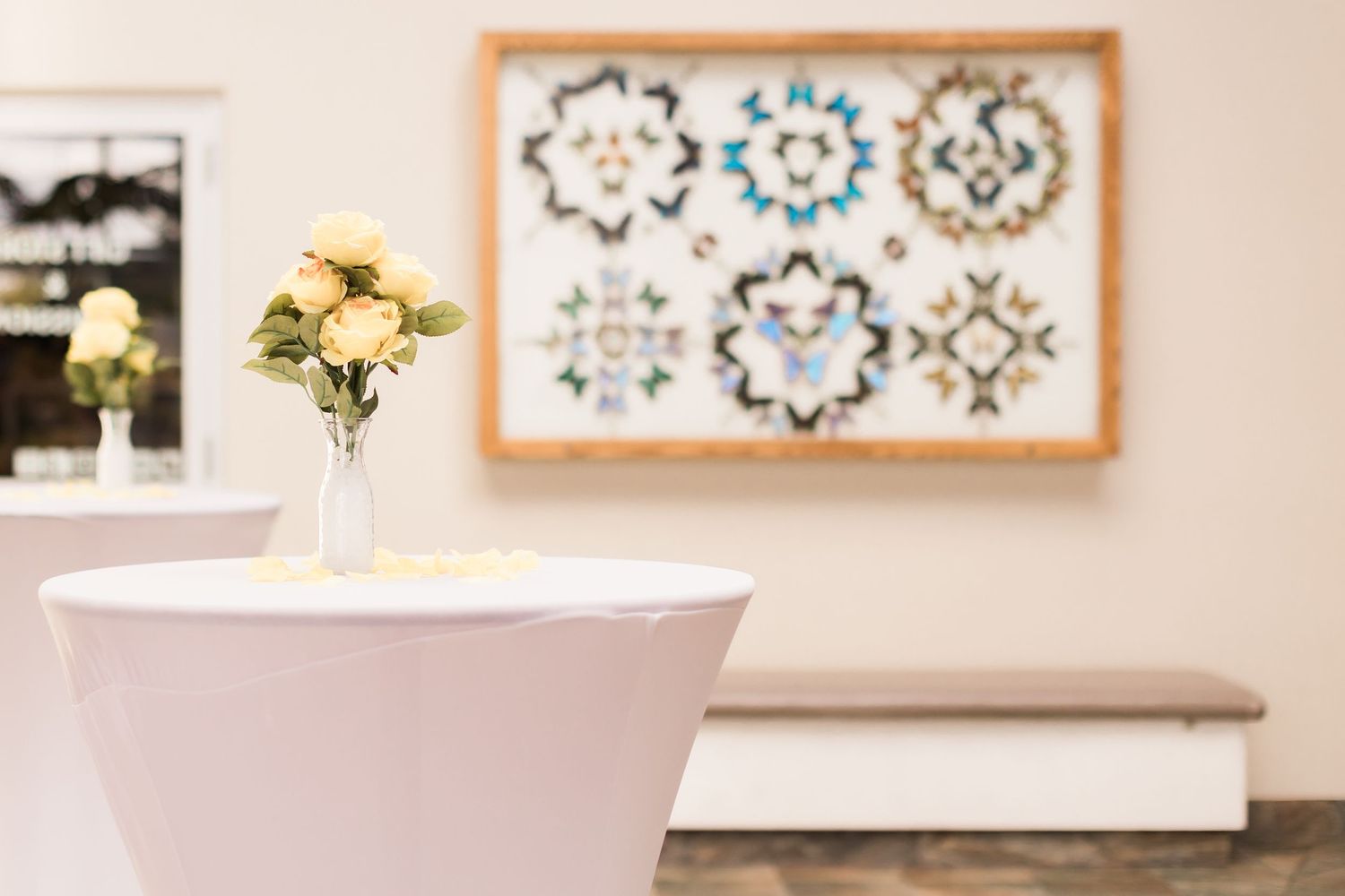Modern interior with framed geometric wall art and white vase of yellow roses.