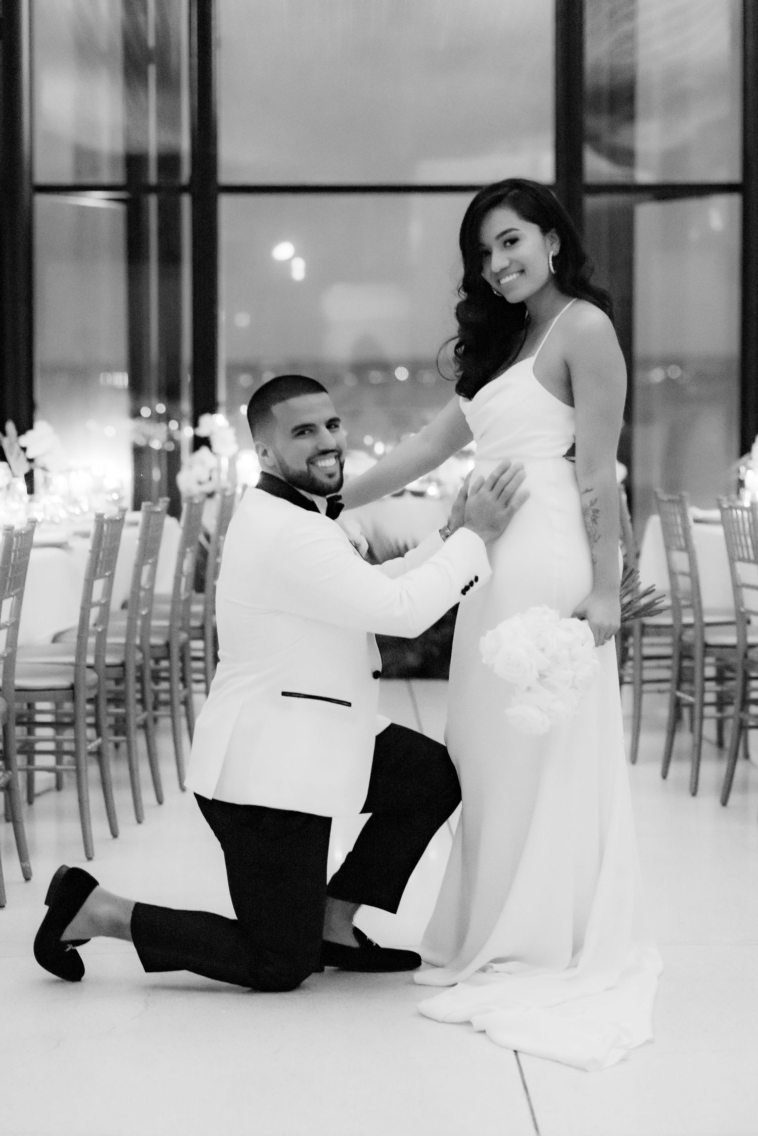 Black and white photo of romantic moment in modern reception venue.