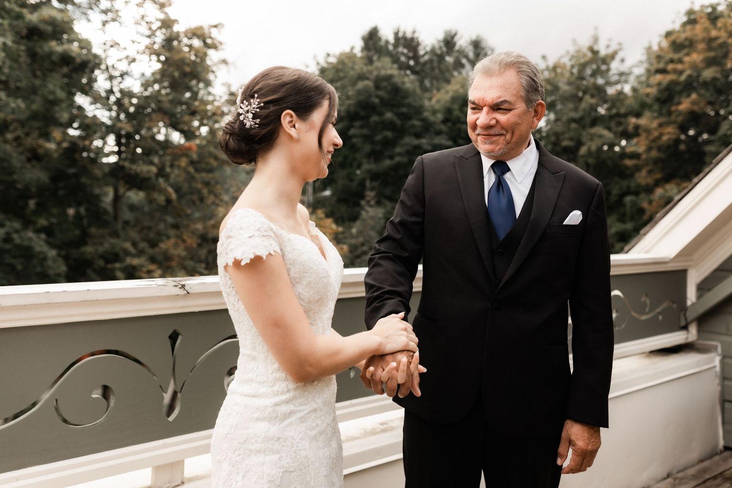 An emotional moment captured during a wedding ceremony on an outdoor balcony.