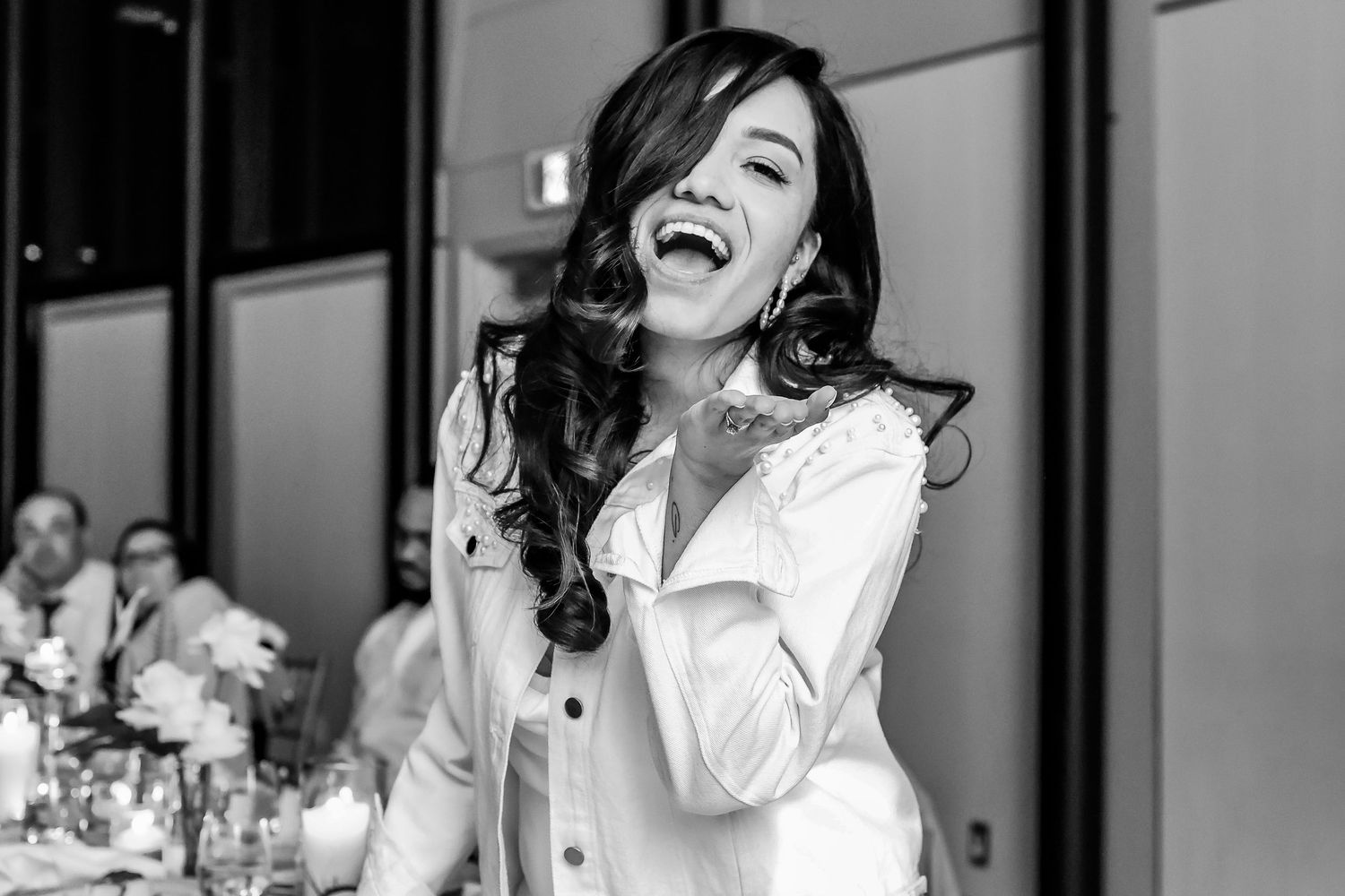 A wedding guest laughs joyfully during the reception celebration.