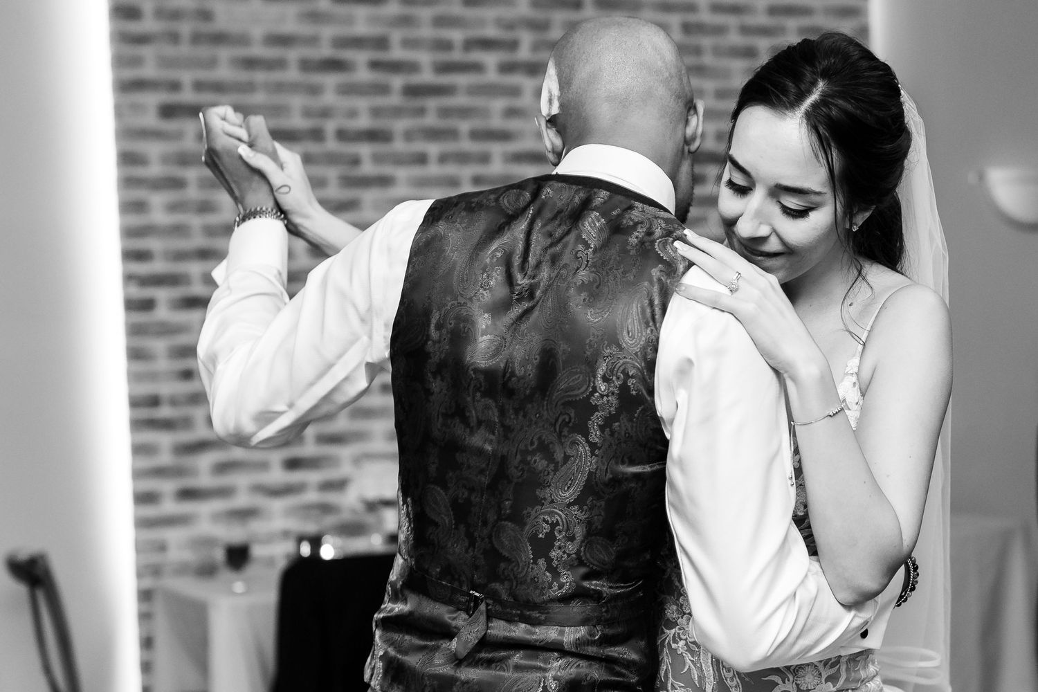 A black and white capture of a tender slow dance between newlyweds.