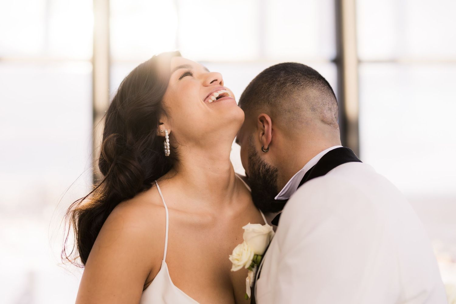 A candid wedding moment captures laughter and joy between the couple.