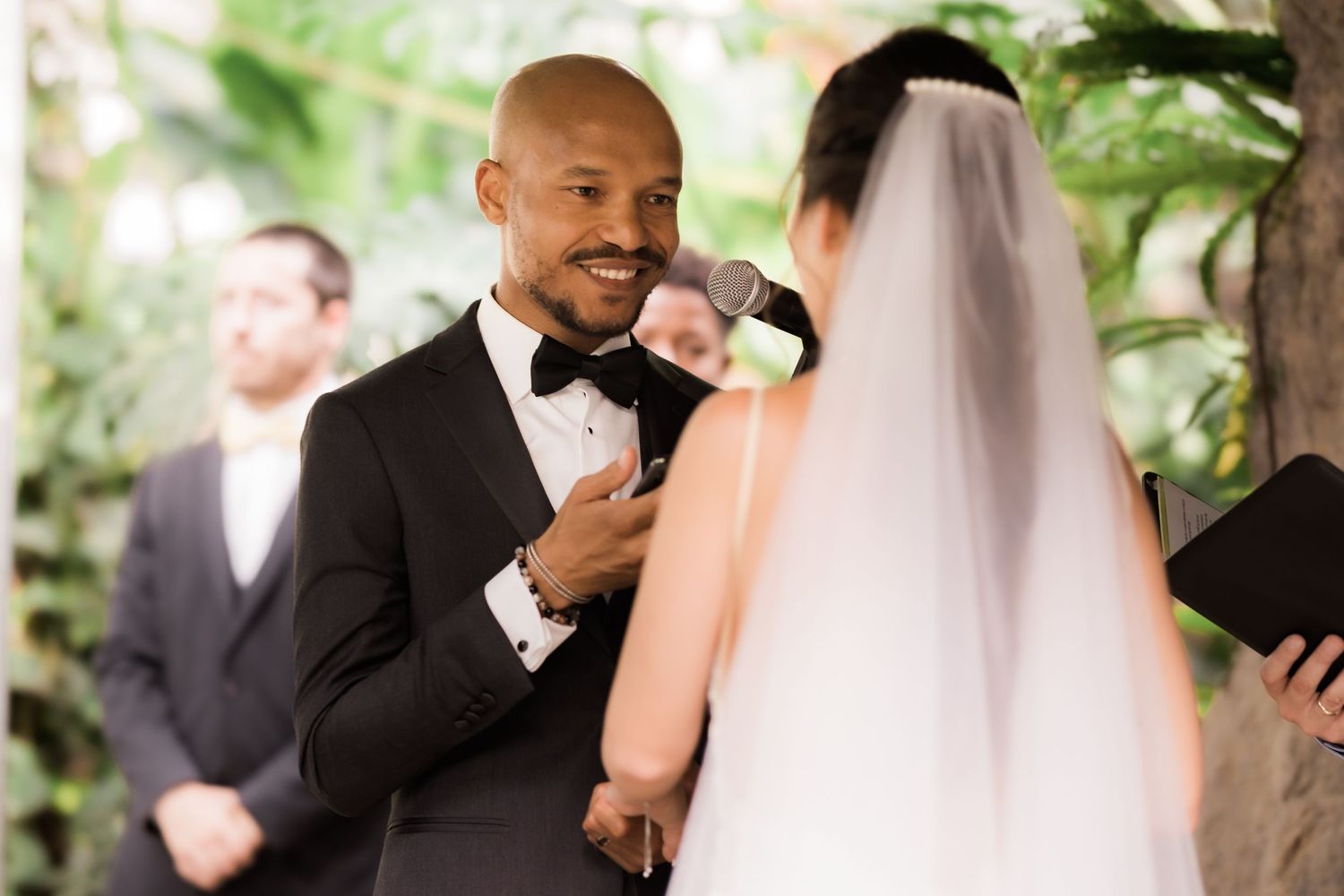 Wedding ceremony moment as couple exchanges emotional vows under floral decor.
