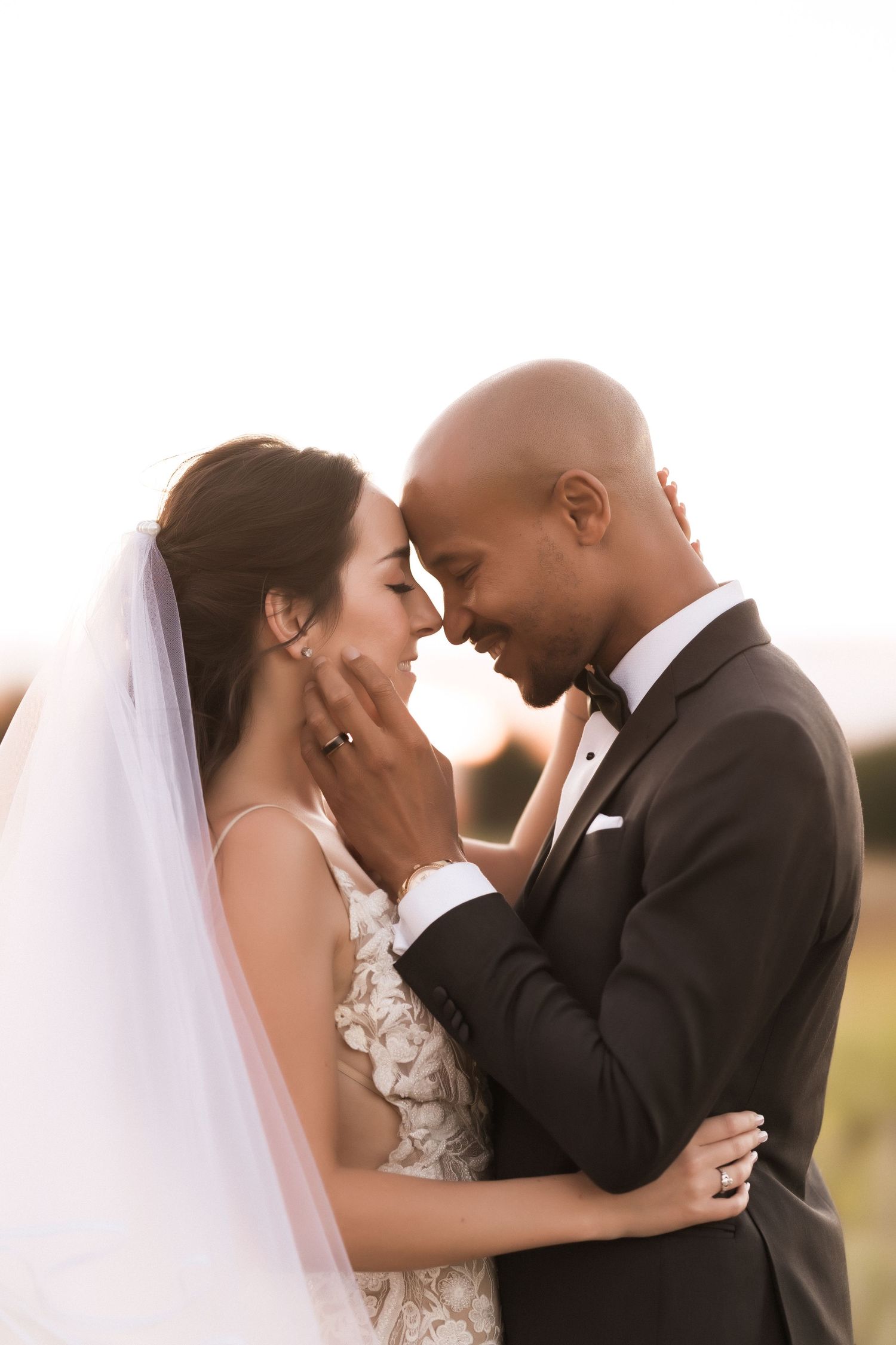Wedding couple shares a loving moment during their outdoor sunset photoshoot.