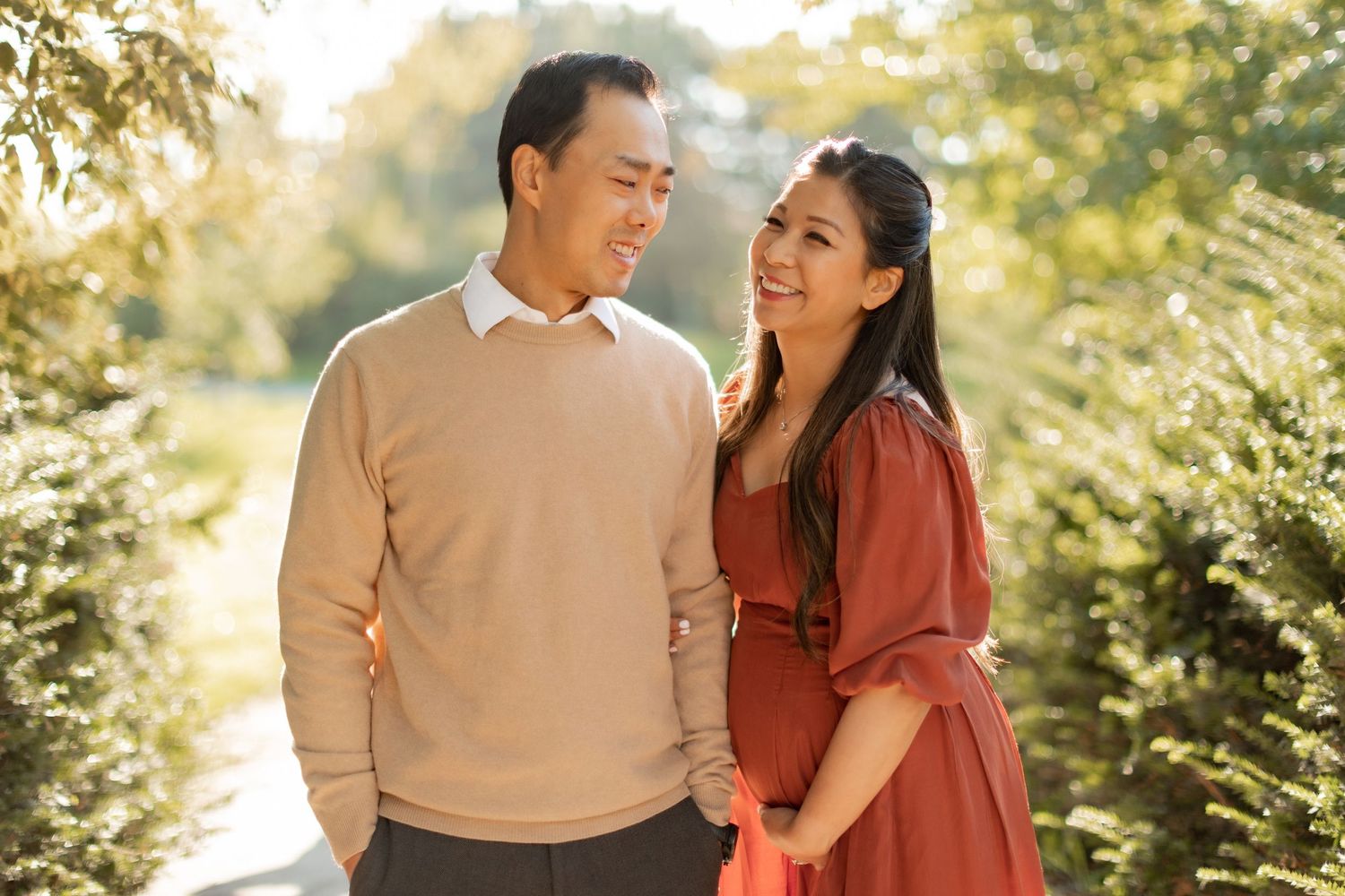 Happy couple in coordinated outfits sharing a loving moment outdoors in golden light.