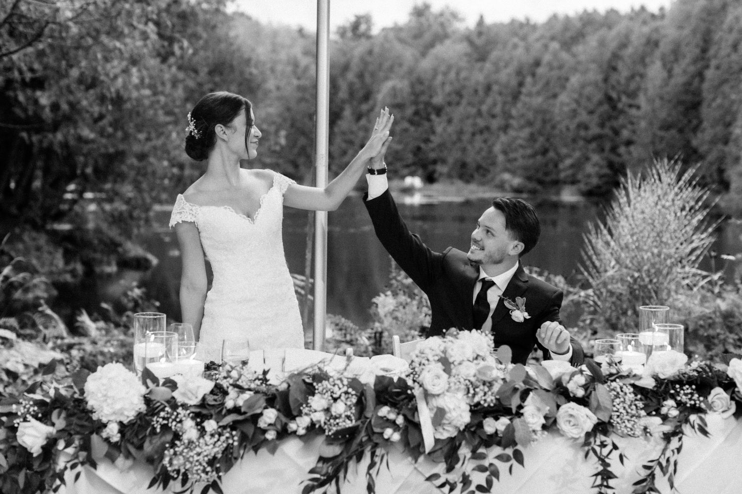 A black and white photo of a wedding reception table with elegant floral decorations.