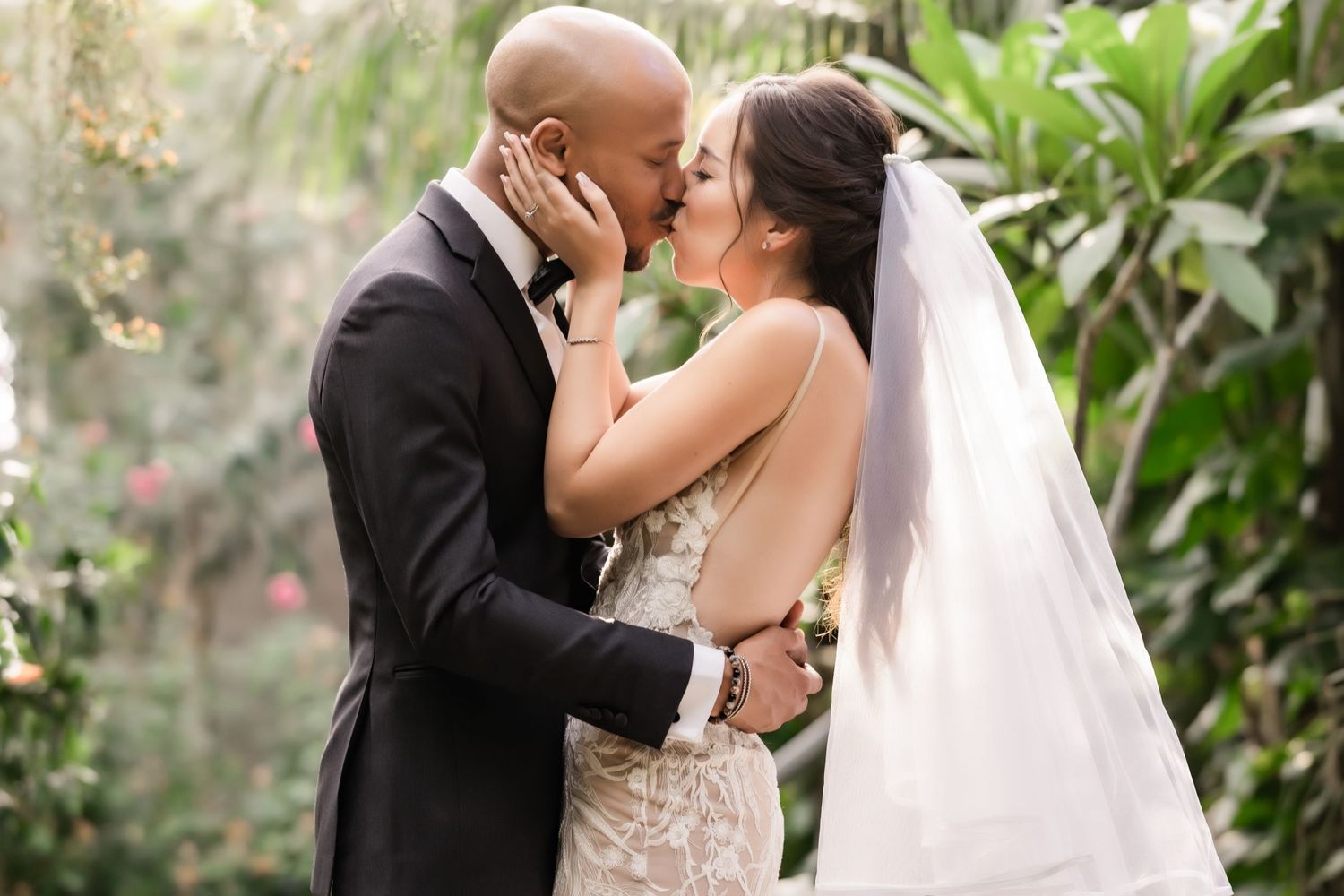 Close-up wedding portrait capturing a loving moment in a botanical garden setting.