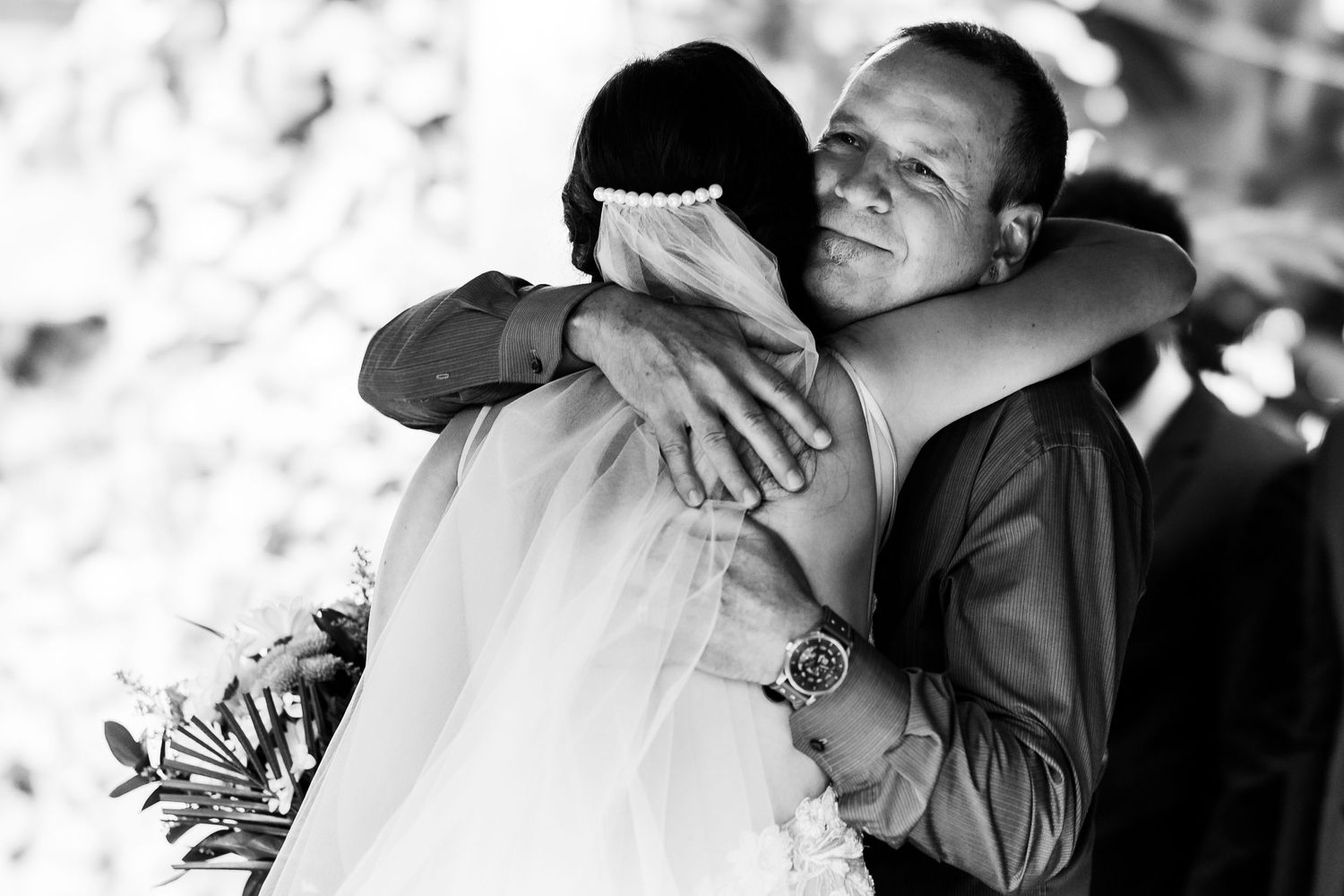 Black and white photo of a tender embrace at a wedding ceremony.