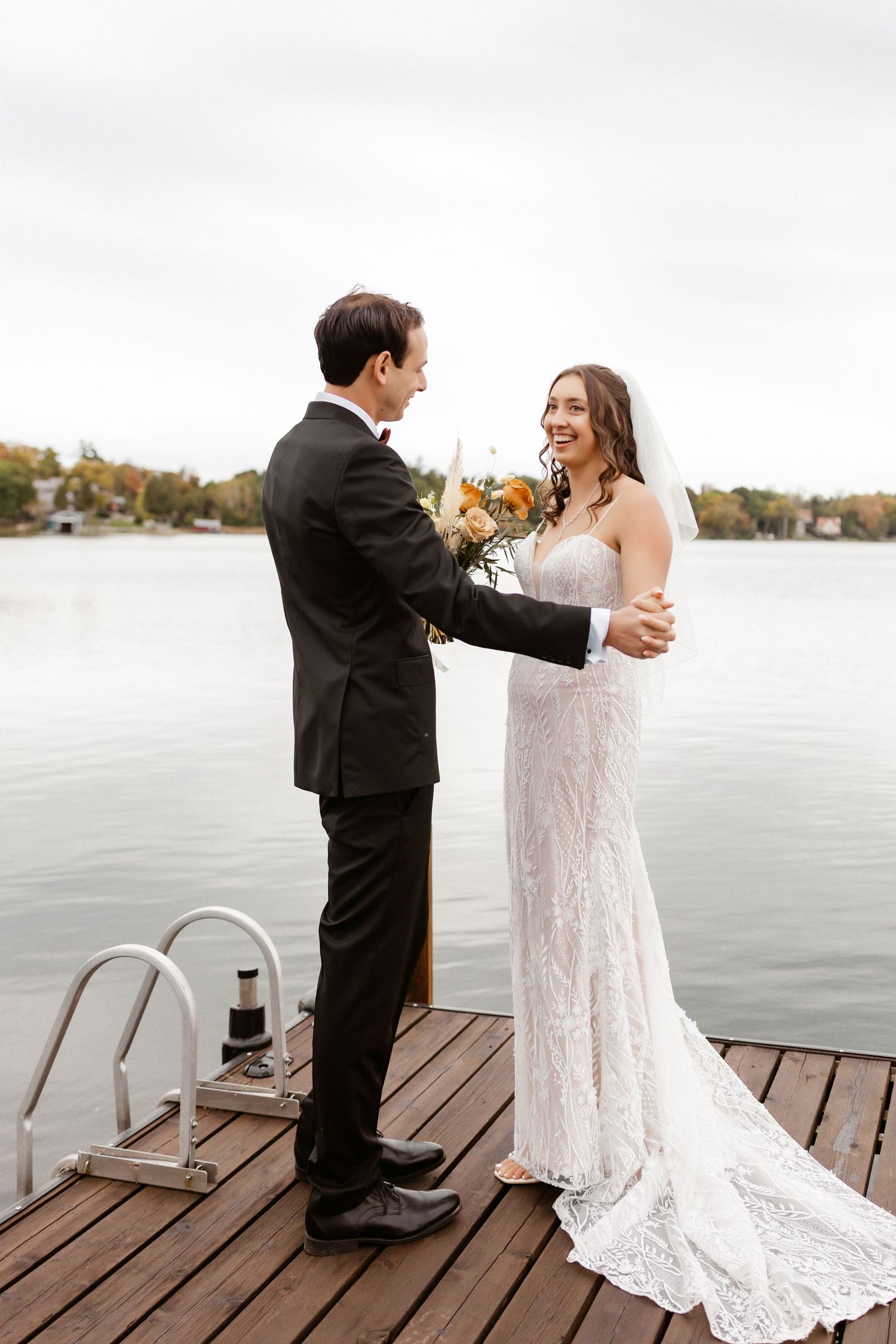 Heartwarming first look sequence of newlyweds sharing joyful reactions on a lakeside dock.