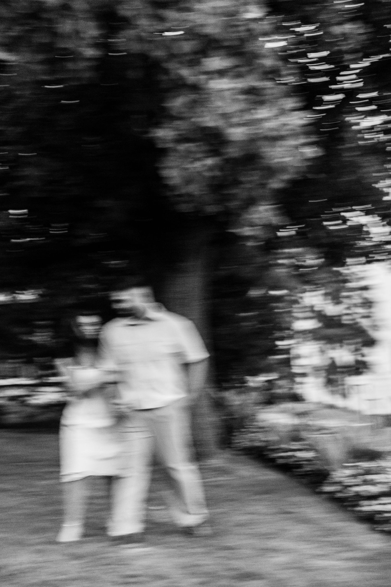 Abstract black and white motion blur of couple walking outdoors.