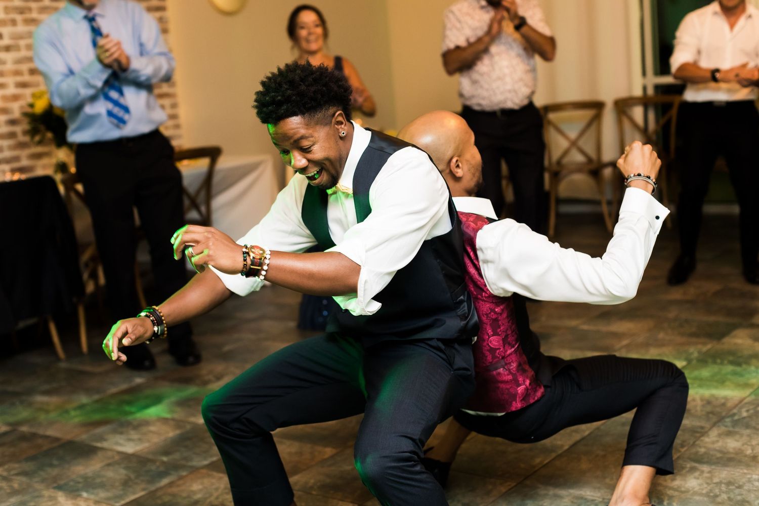 Wedding guest performs dynamic dance moves during lively reception celebration.