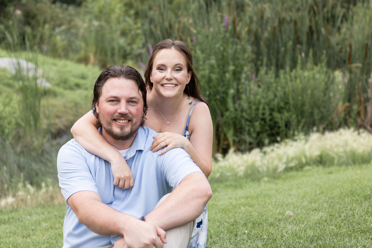 A playful outdoor portrait in a natural setting with green grass and trees.