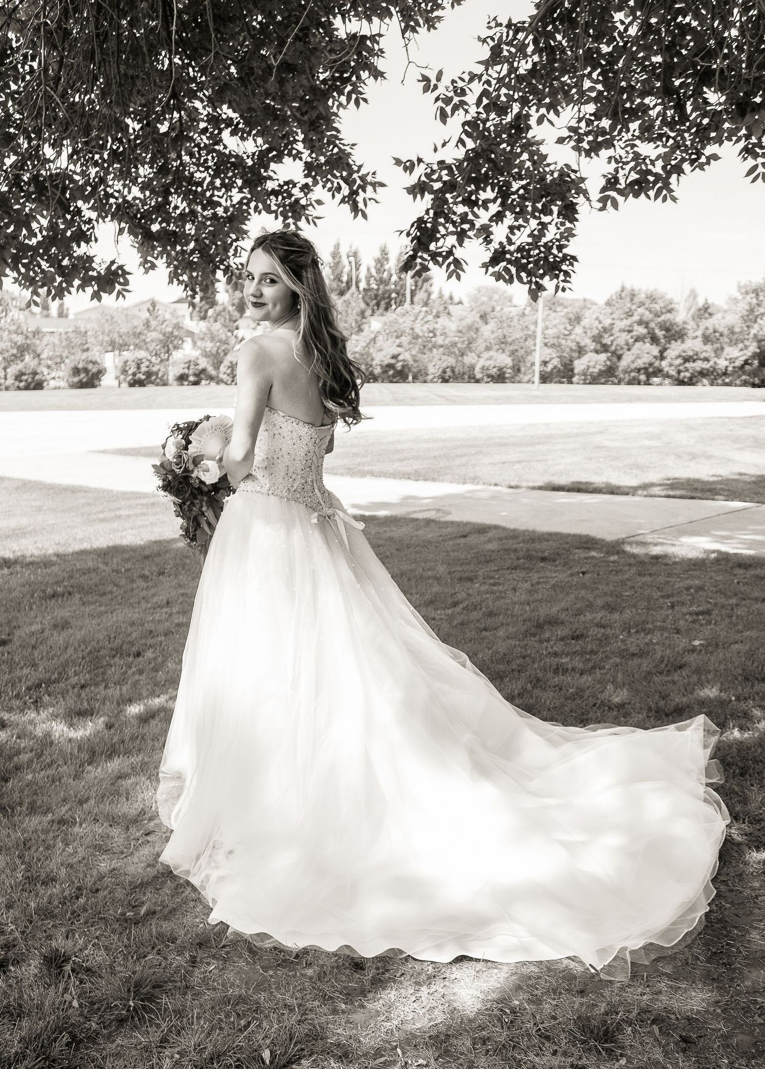 Artistic bridal portrait in black and white showing elegant wedding dress details.