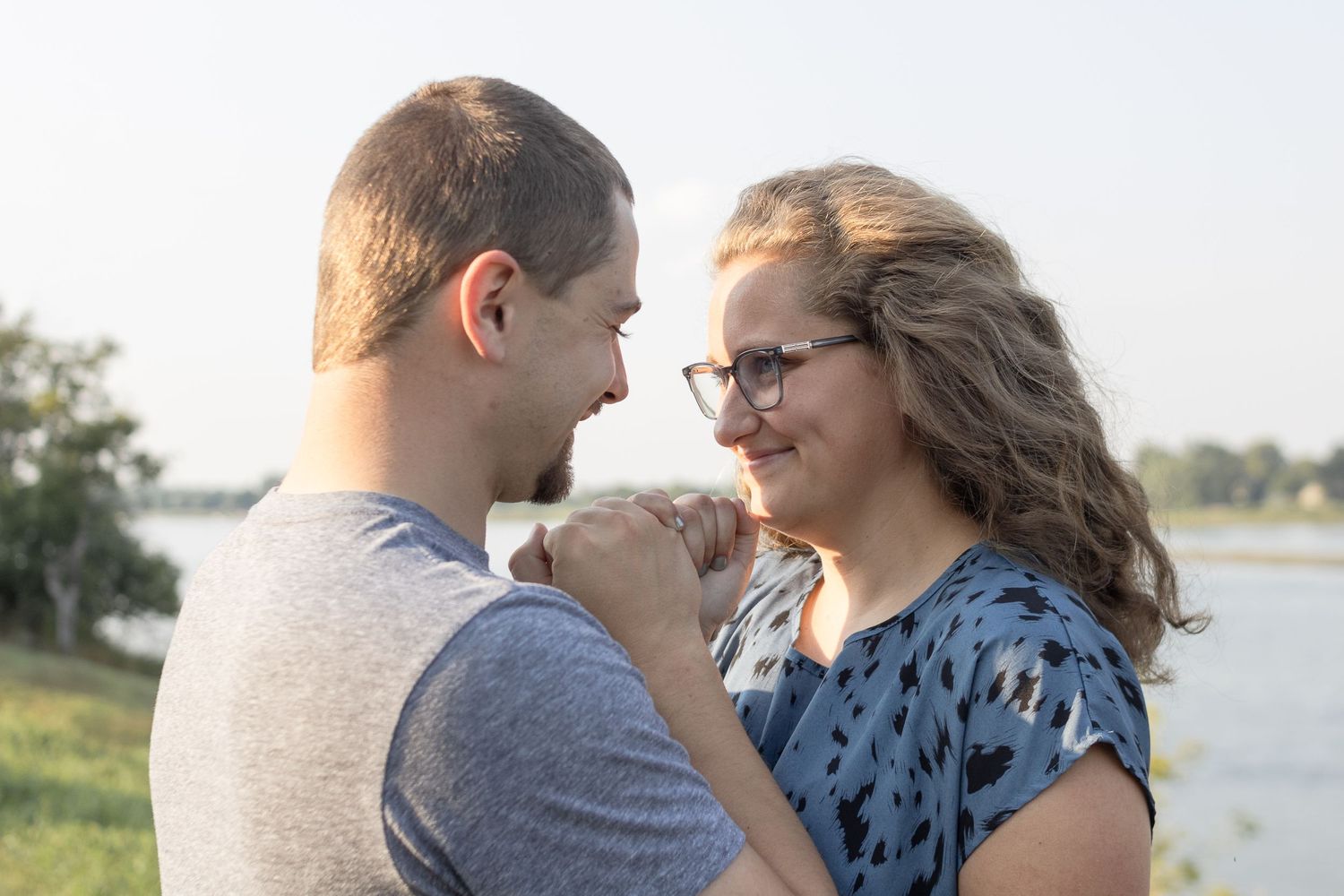 A tender moment captured between a couple by a waterfront.