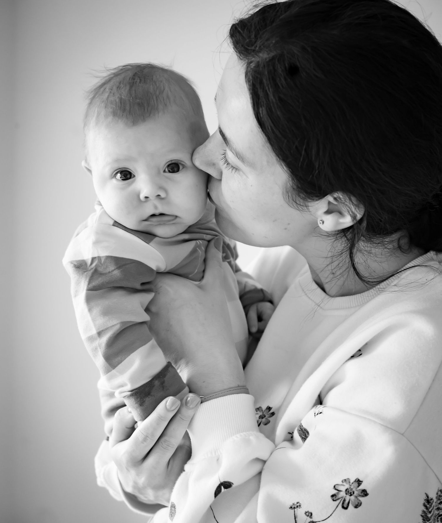 A tender black and white photo series showing intimate moments between a parent and baby.