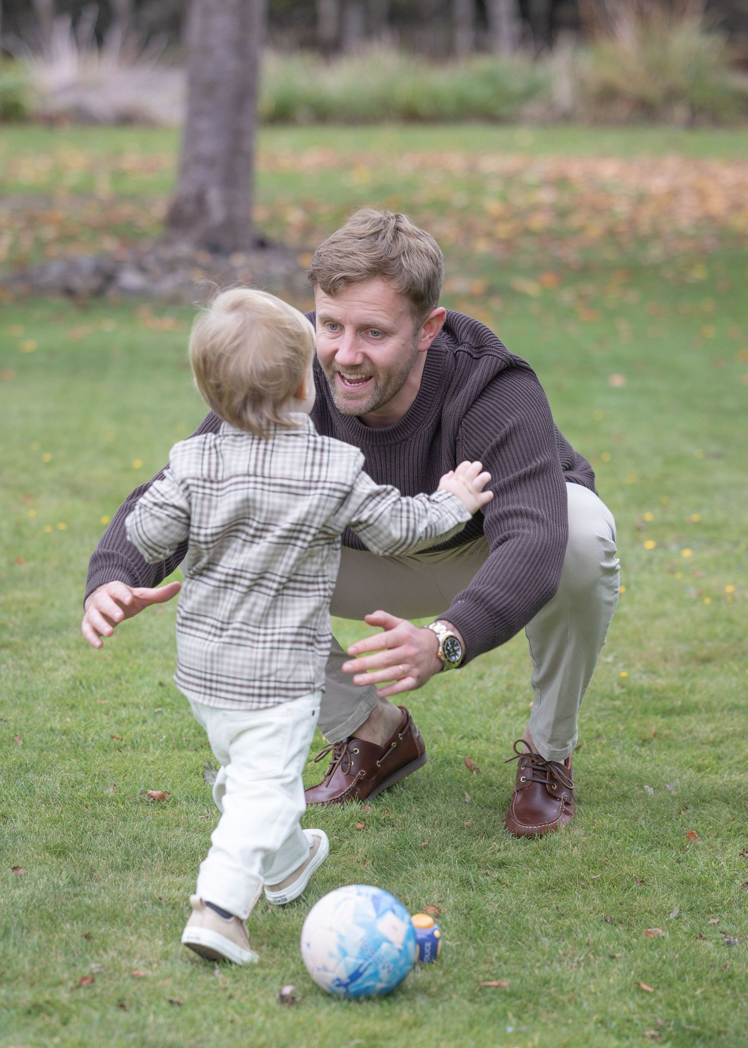 A sequence of outdoor playtime with a blue ball on grass during autumn.