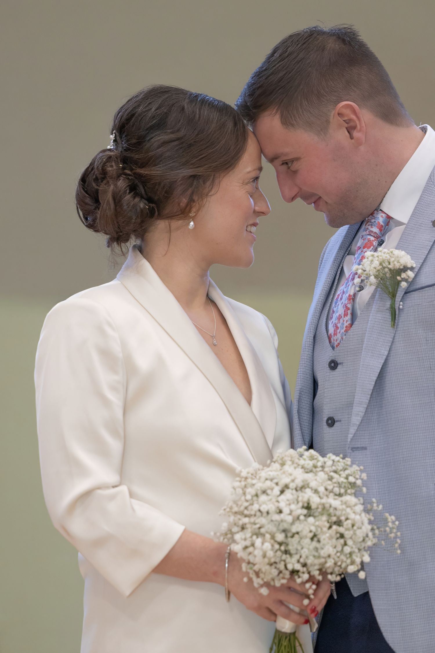 A romantic wedding couple shares intimate moments in a sequence of photos with the bride holding baby's breath flowers.
