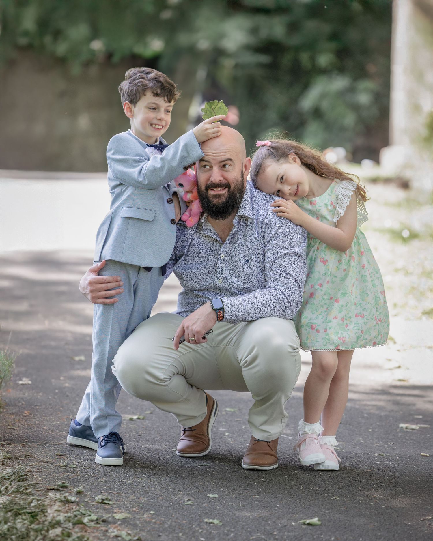 A candid family portrait series showing playful outdoor interactions in matching gray and blue outfits.