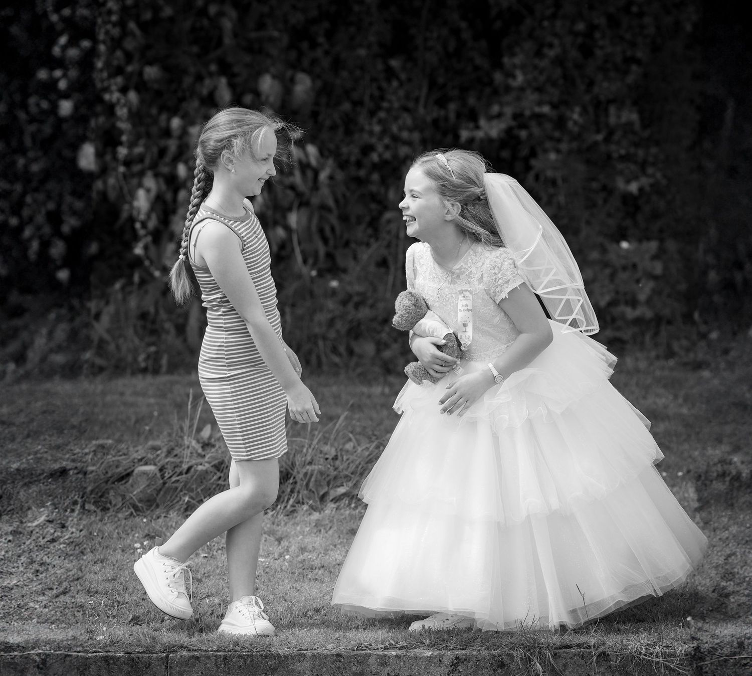 Black and white photo series showing a bride in a flowing white dress twirling and dancing in an outdoor garden setting.