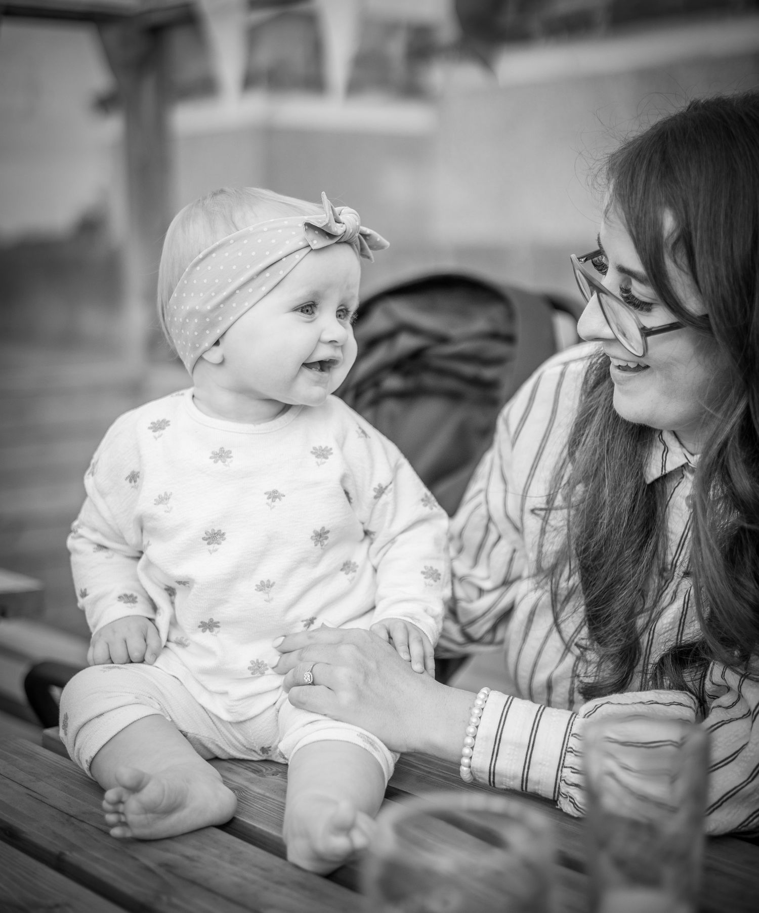A series of black and white photographs showing tender moments between a caregiver and infant in matching outfits.