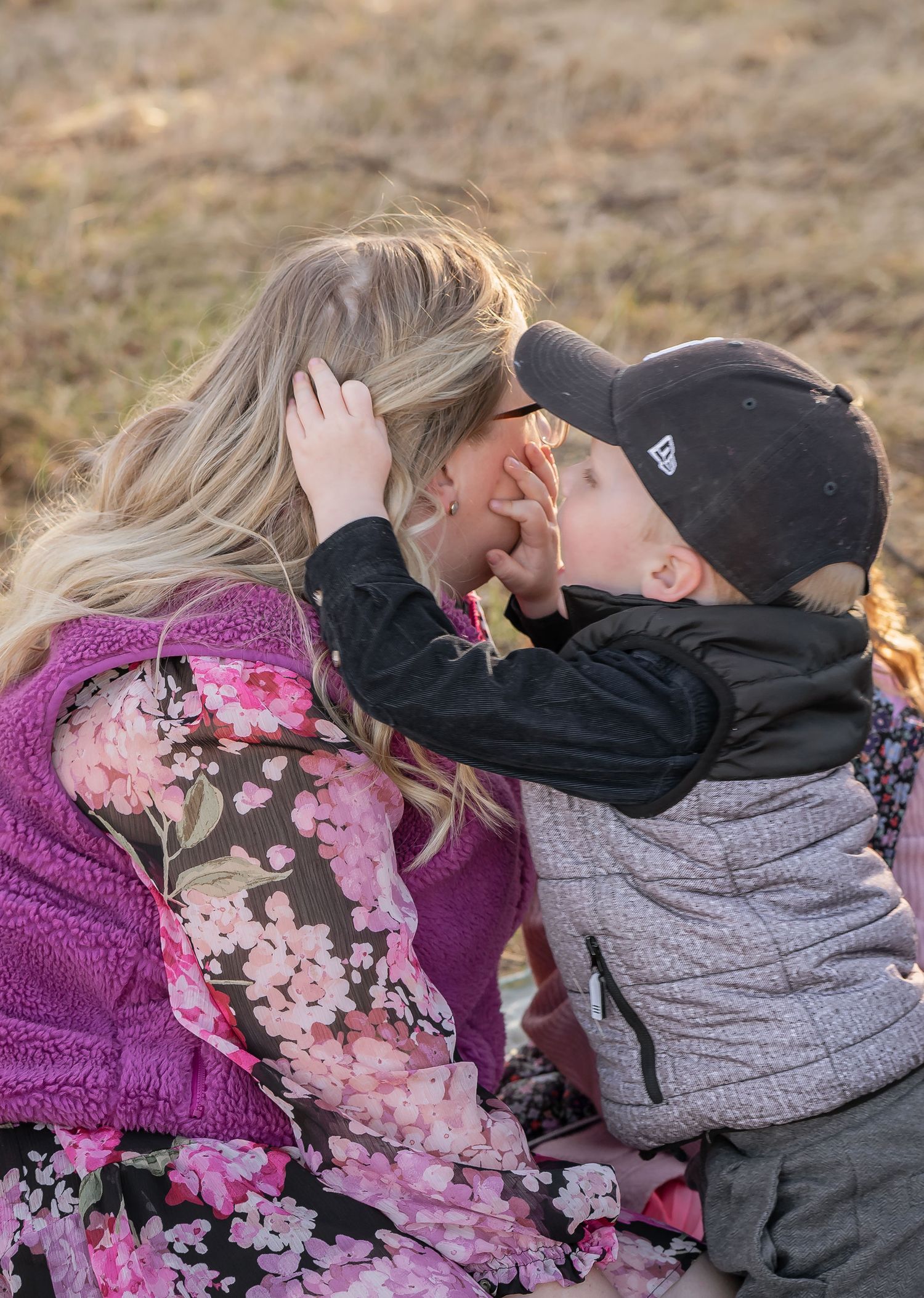 Tender moment captured between parent and child during outdoor sunset photo session.