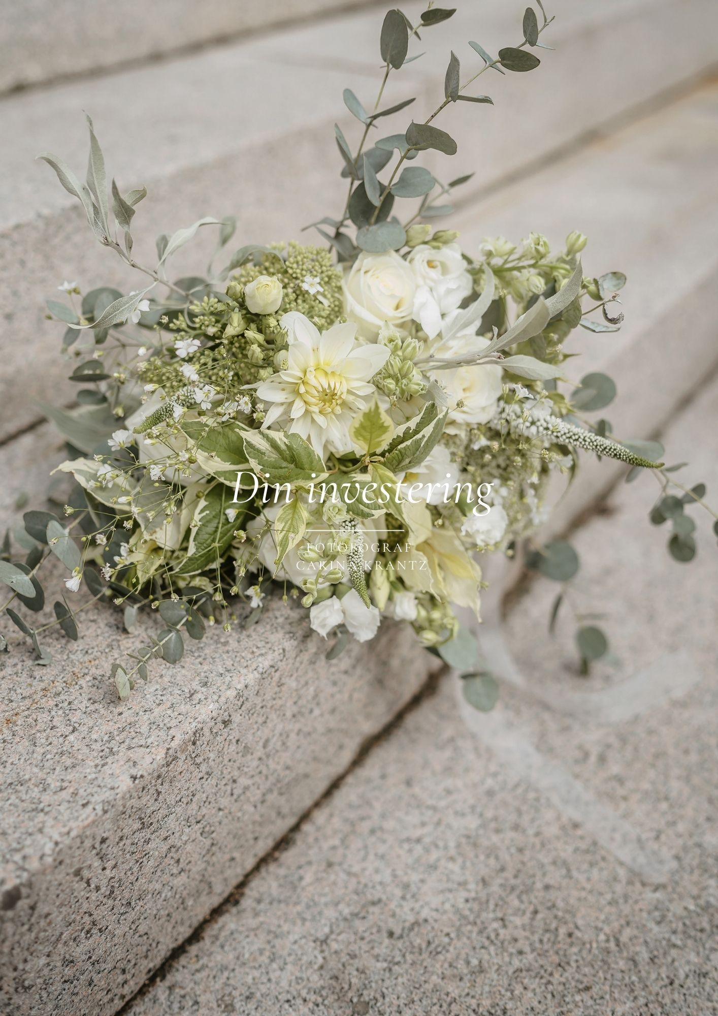 A delicate white and green bridal bouquet with eucalyptus leaves rests on concrete steps in soft lighting.