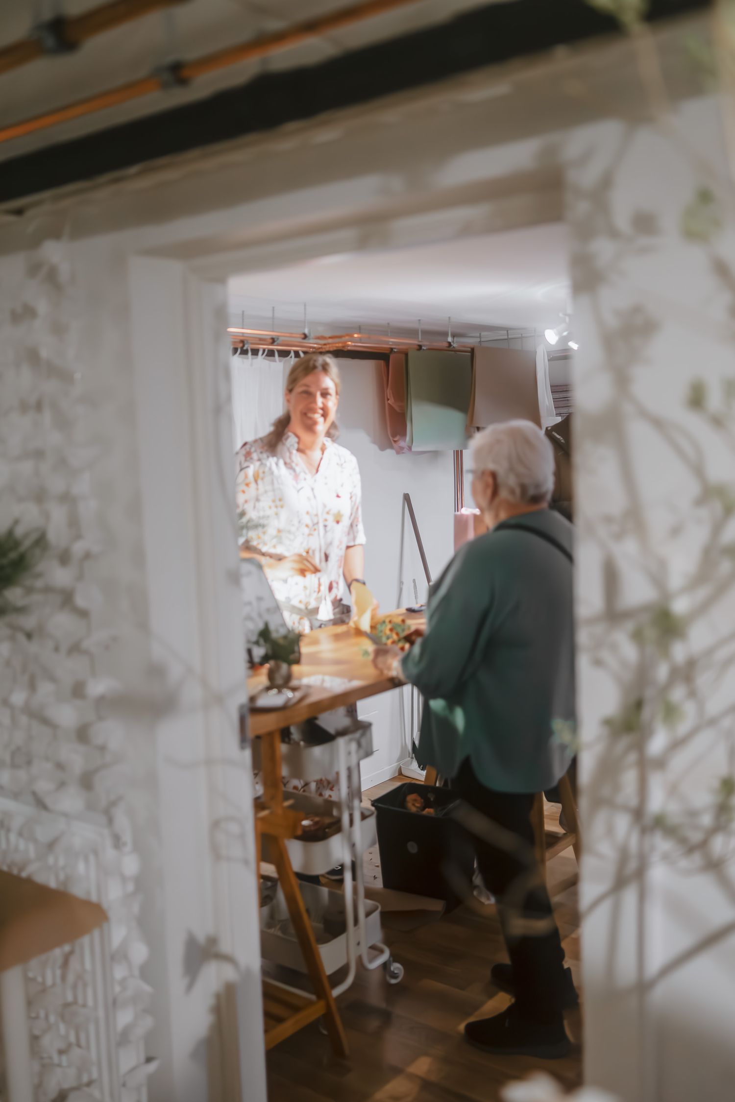 Two people having a conversation in a rustic kitchen setting.