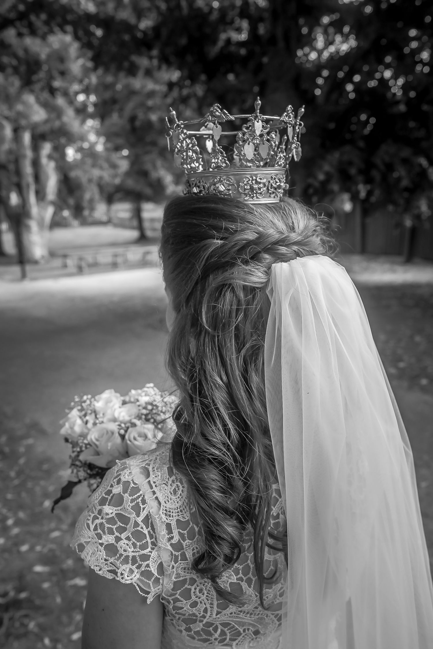 Close-up of ornate silver crown and veil on styled bridal hair.