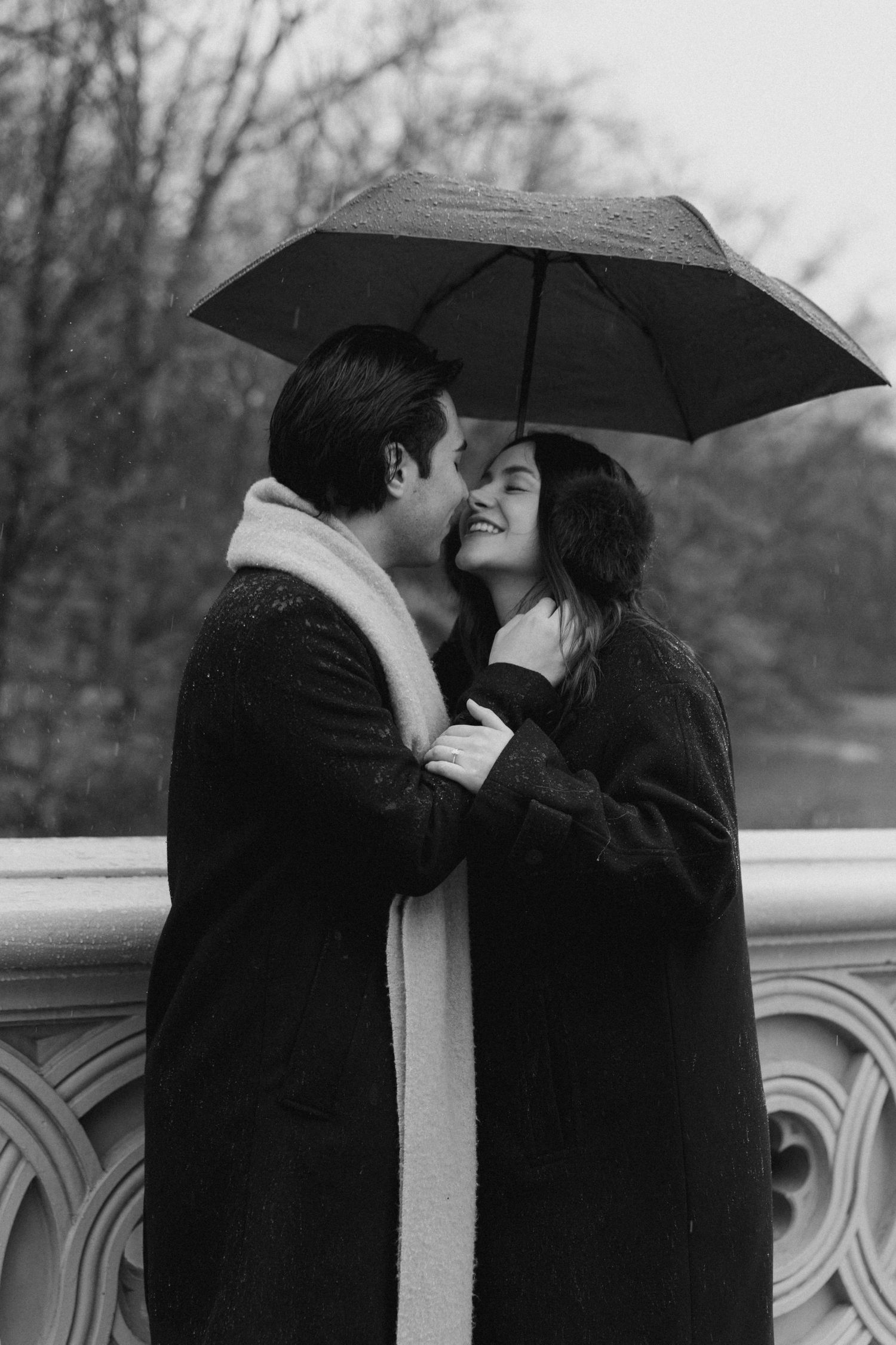 A romantic black and white sequence shows a couple sharing an intimate moment under a black umbrella in the rain.