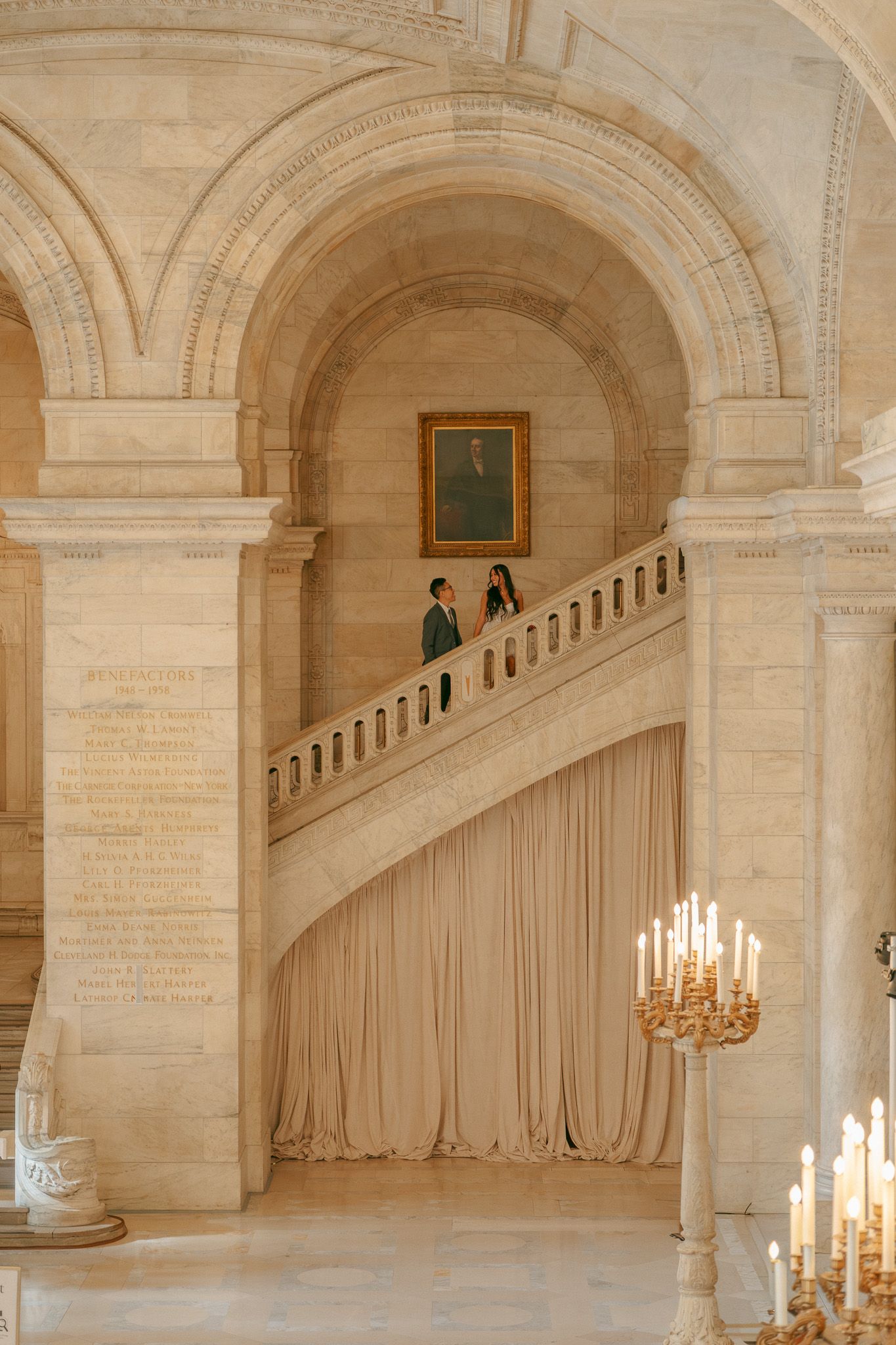 An elegant interior hallway with arched ceilings and candle chandeliers in a historic building.