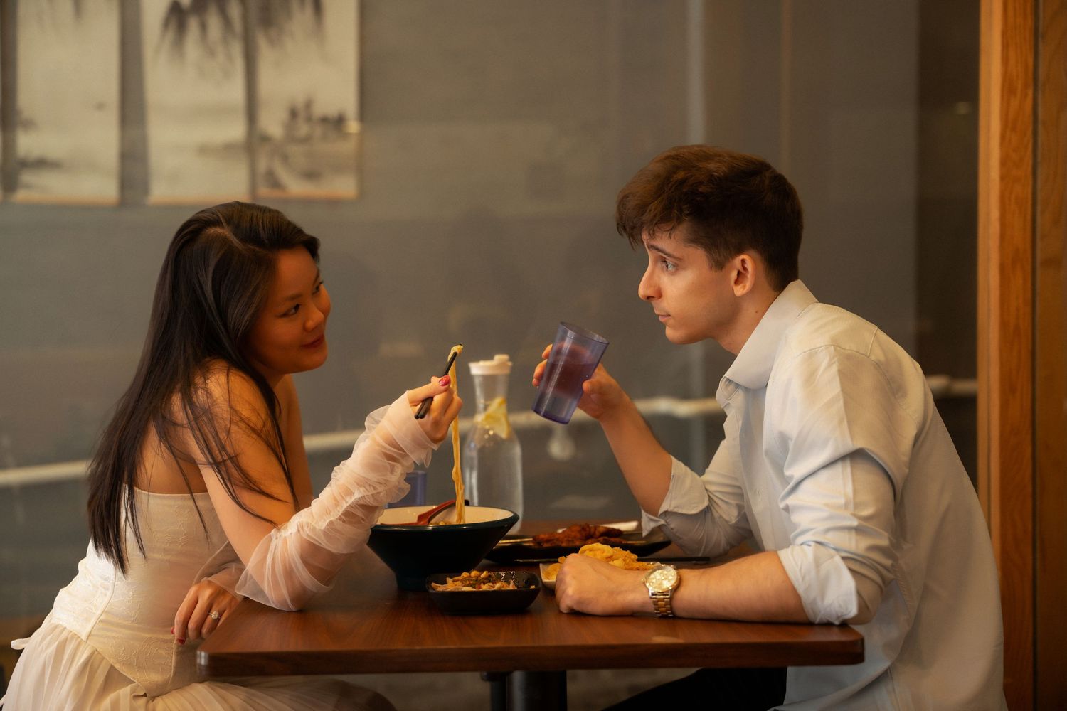 Couple sharing a romantic dinner date at a restaurant table, enjoying Asian cuisine together.