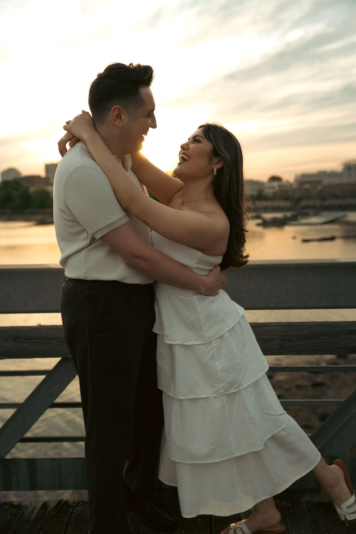 A romantic sunset dance between a couple on a waterfront boardwalk.