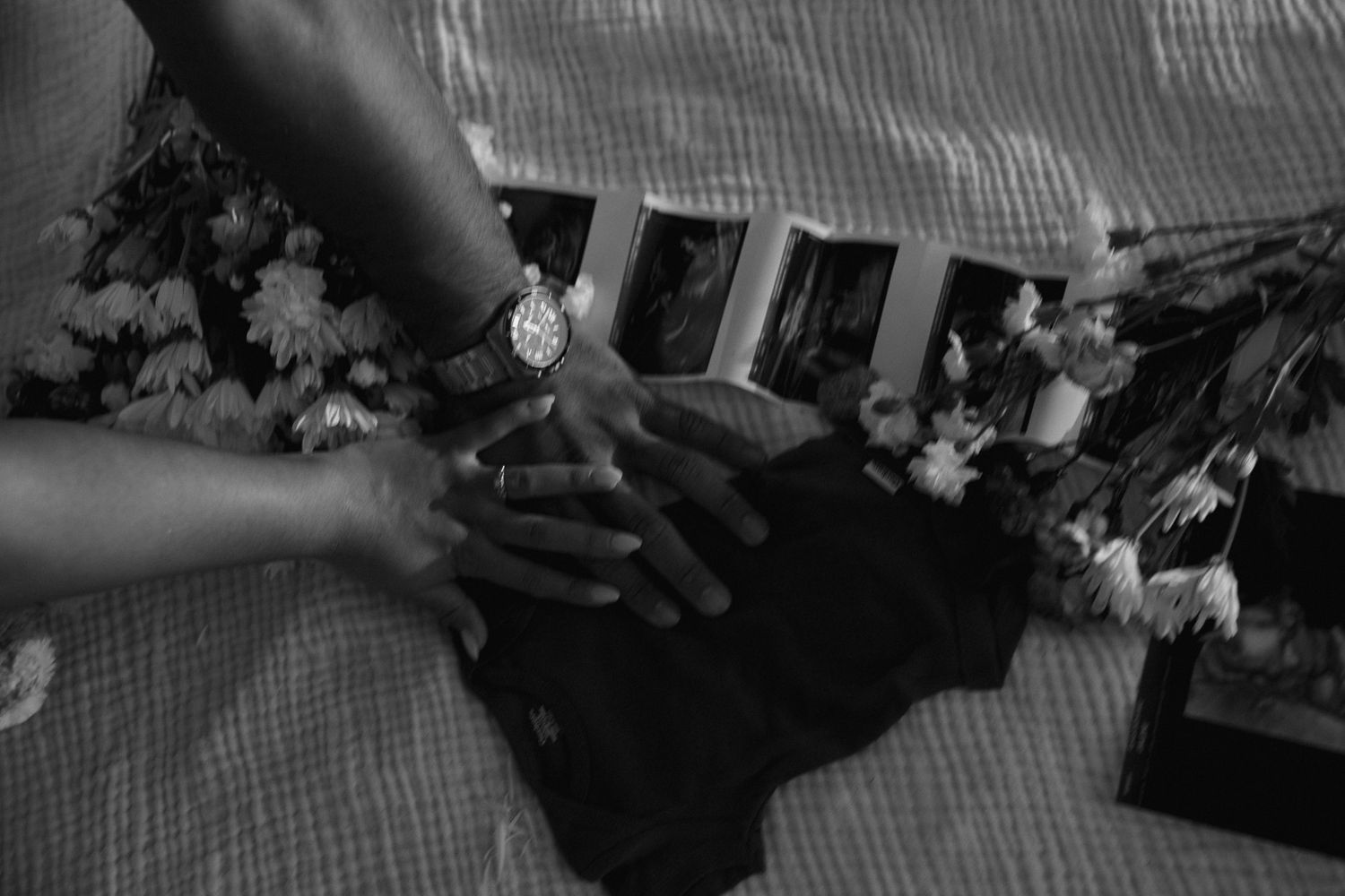 Collection of black and white photographs laid out on a textured fabric surface.