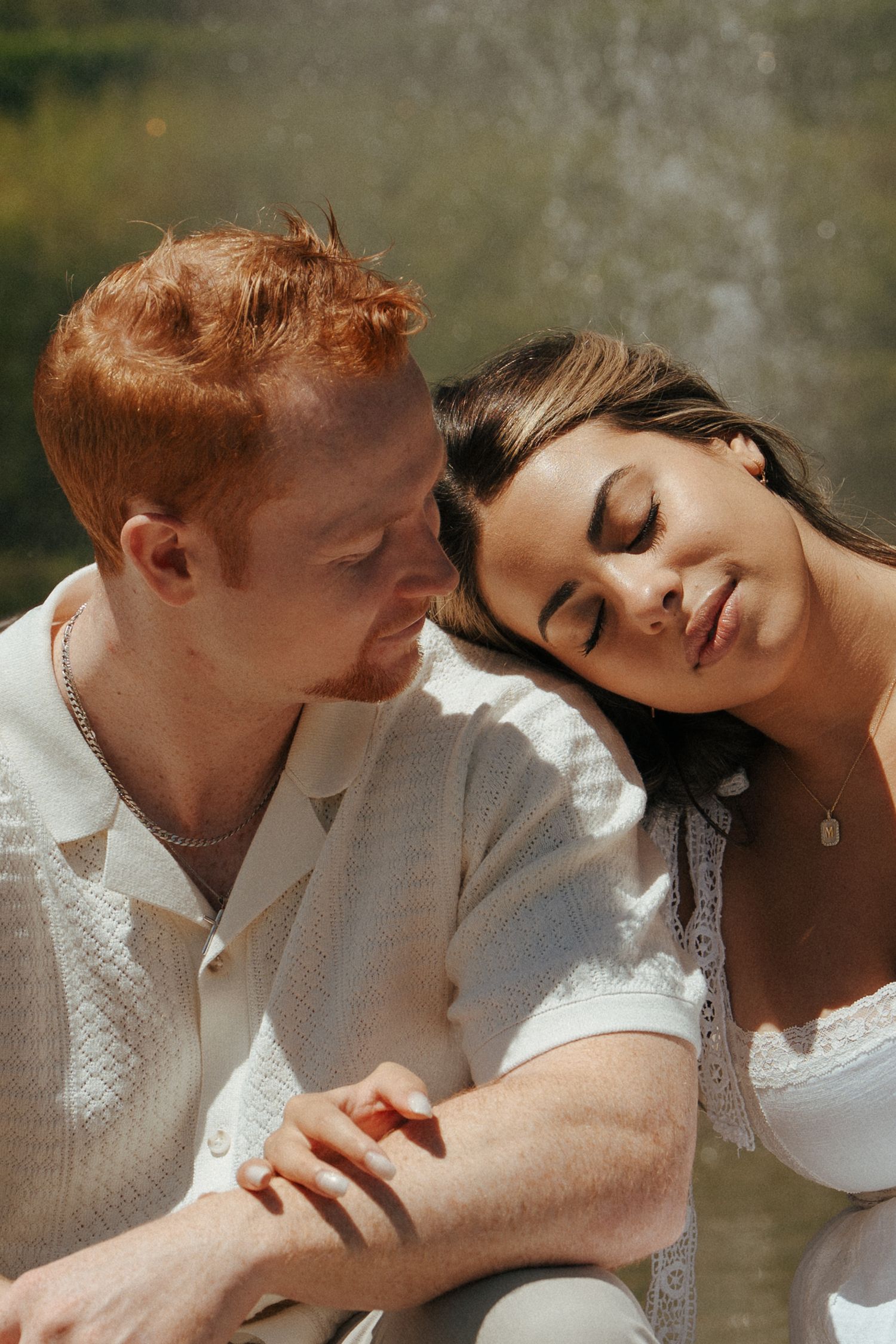 Romantic couple in white clothing sharing intimate moments in warm sunlight.