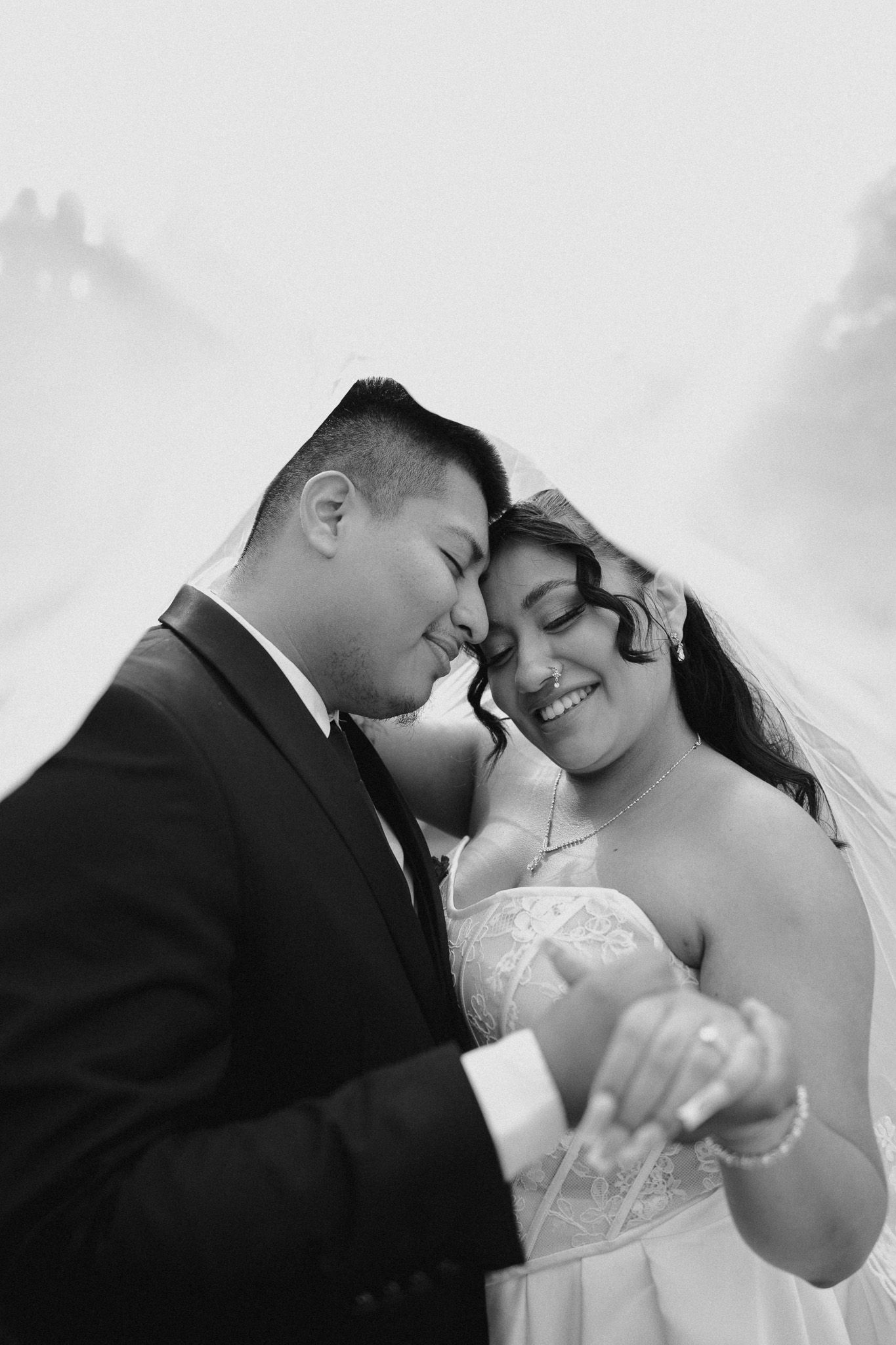 Intimate black and white portrait of newlyweds sharing a tender moment.