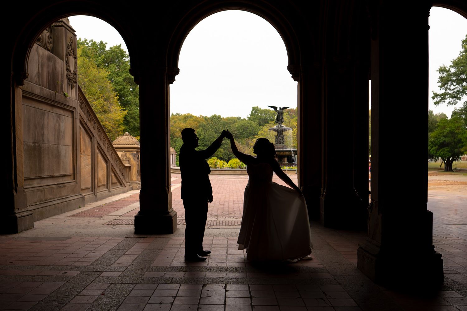 Silhouetted figures under architectural arches creating dramatic shadows.