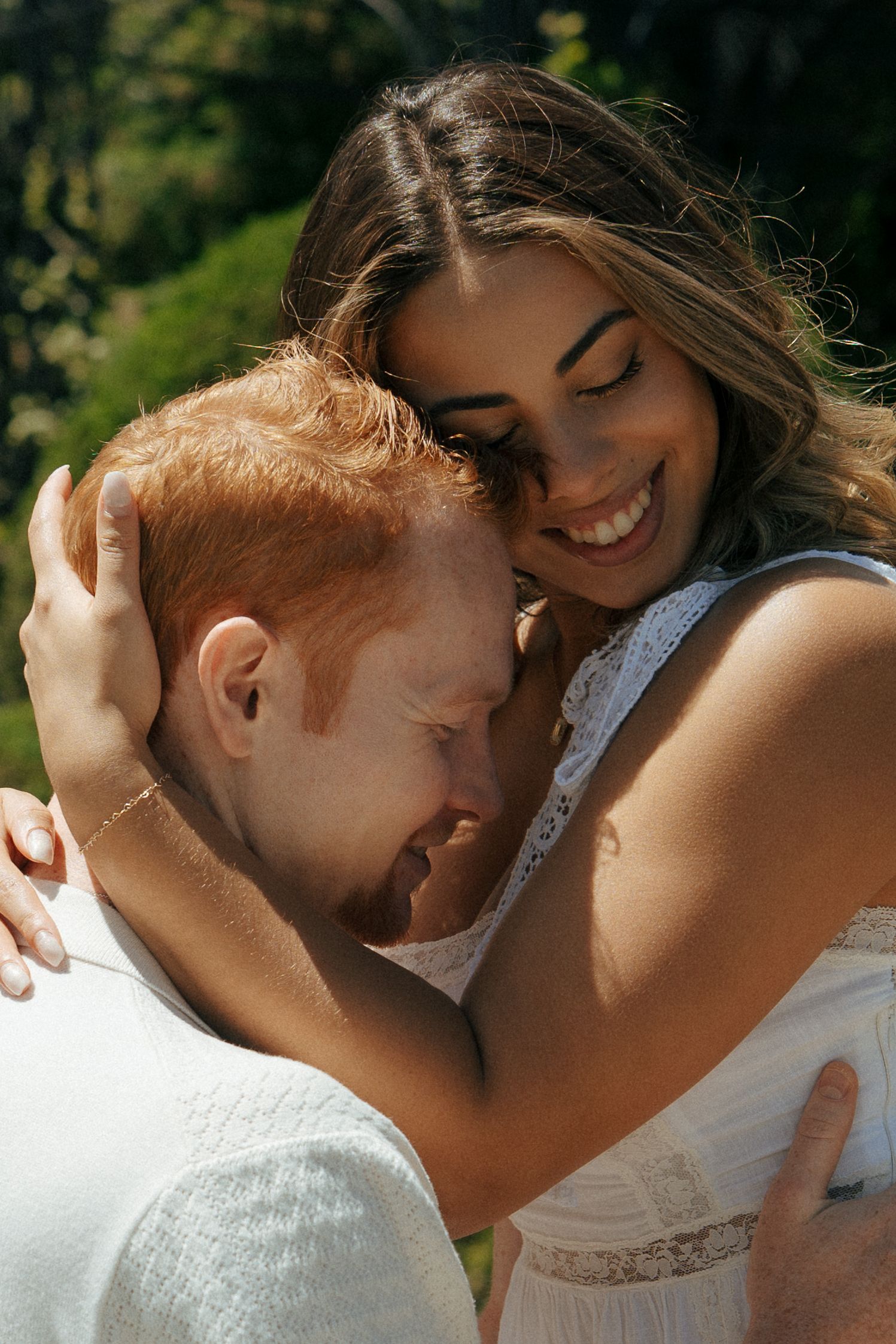 Close-up sequence of intimate moments between a couple in white clothing outdoors.
