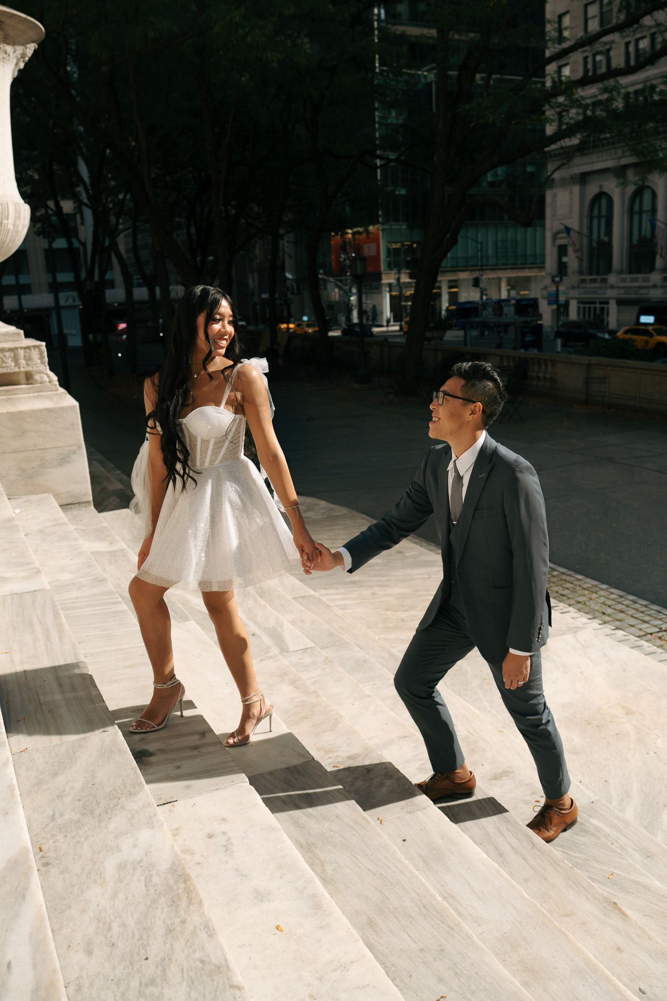 A sequence showing a couple in formal attire interacting on white stone steps.
