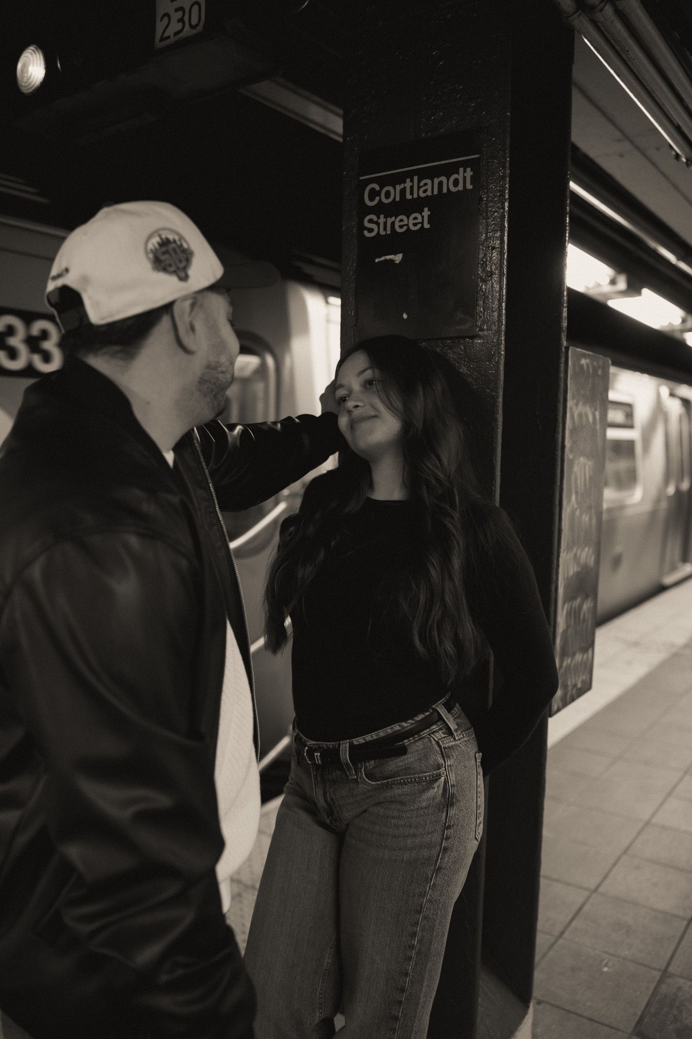 A couple embraces near a subway station sign at Cortlandt Street.