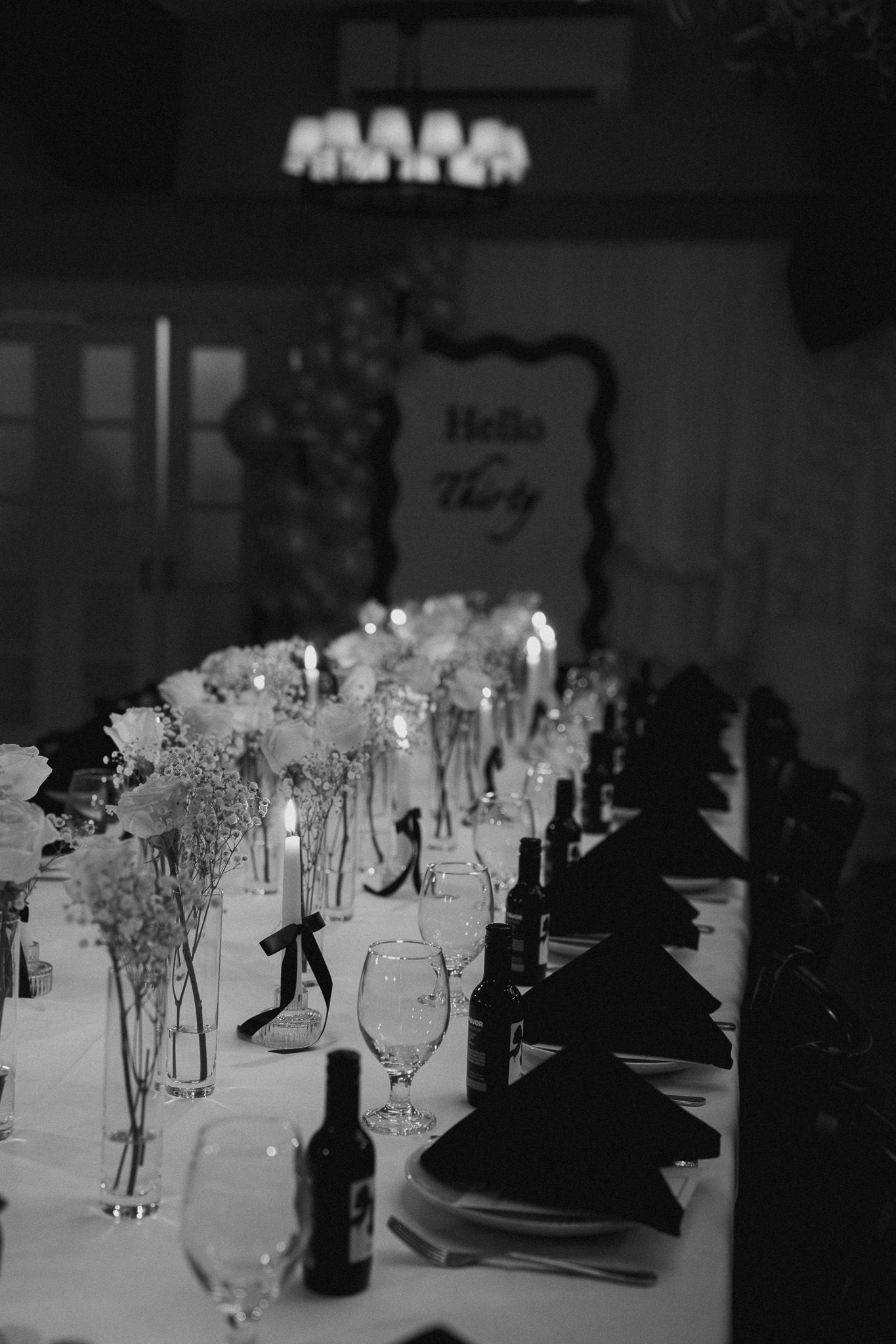 Elegant black and white banquet table setting with champagne glasses and dark napkins arranged in a formal dining layout.