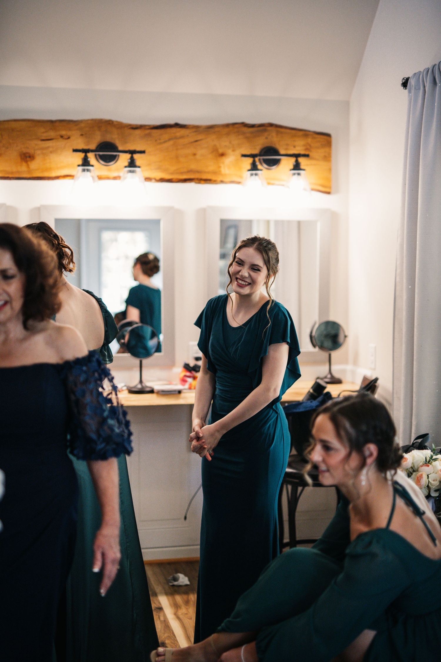 Wedding party getting ready in a bridal suite with rustic wood beam lighting.